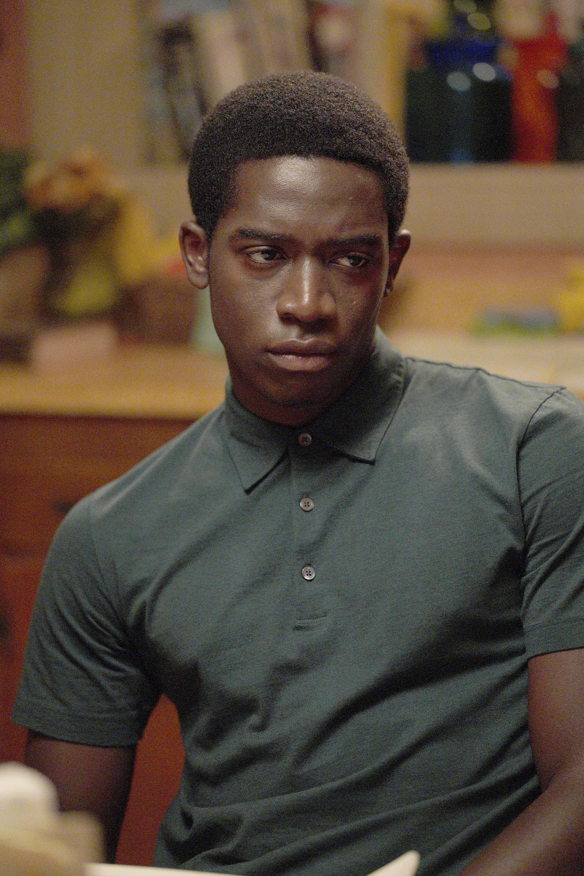 Franklin Saint, dark green polo shirt, warmly lit room, 2K Phone Wallpaper
