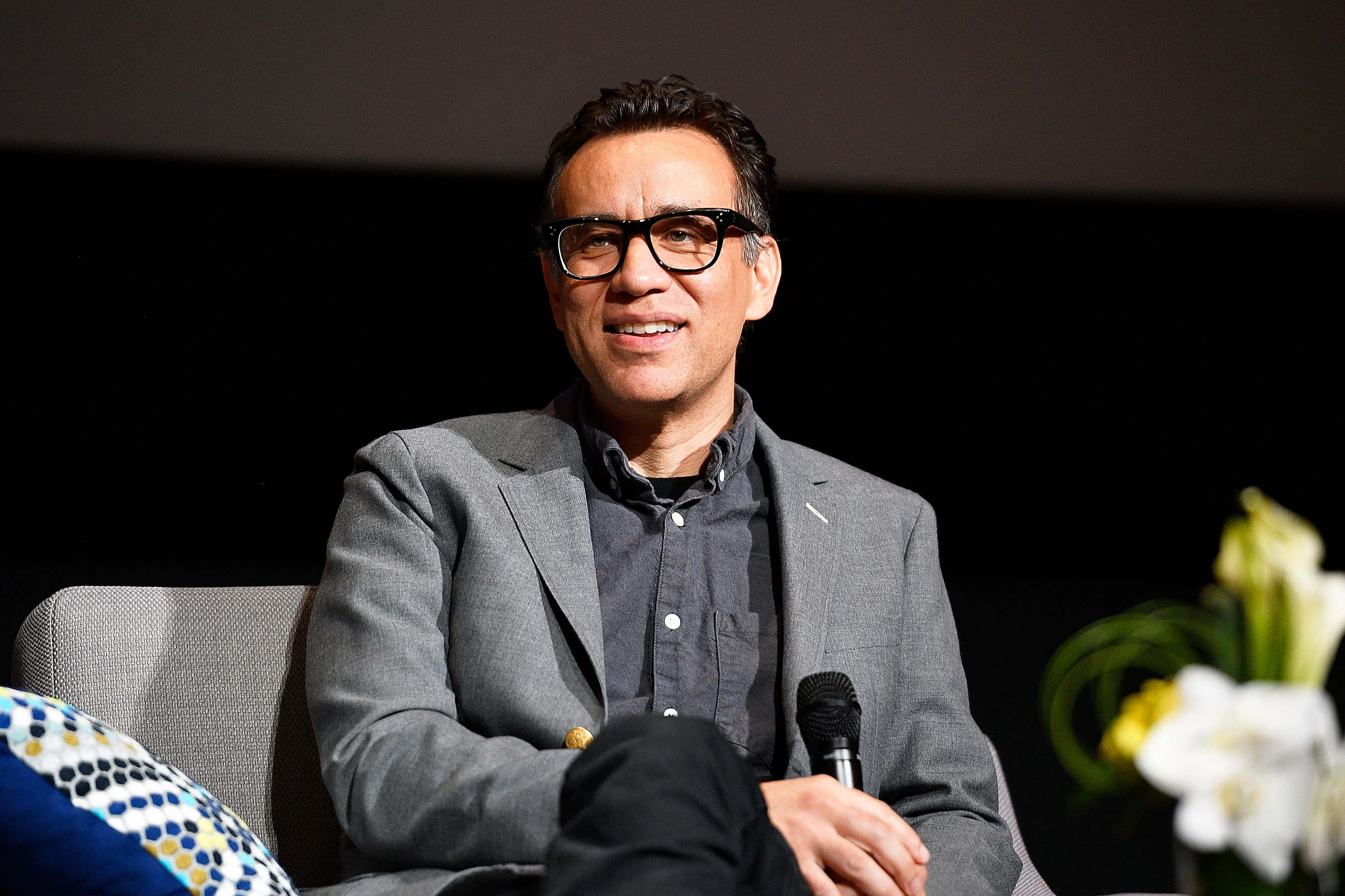 fred armisen, glasses, gray chair, 2K Desktop Wallpaper