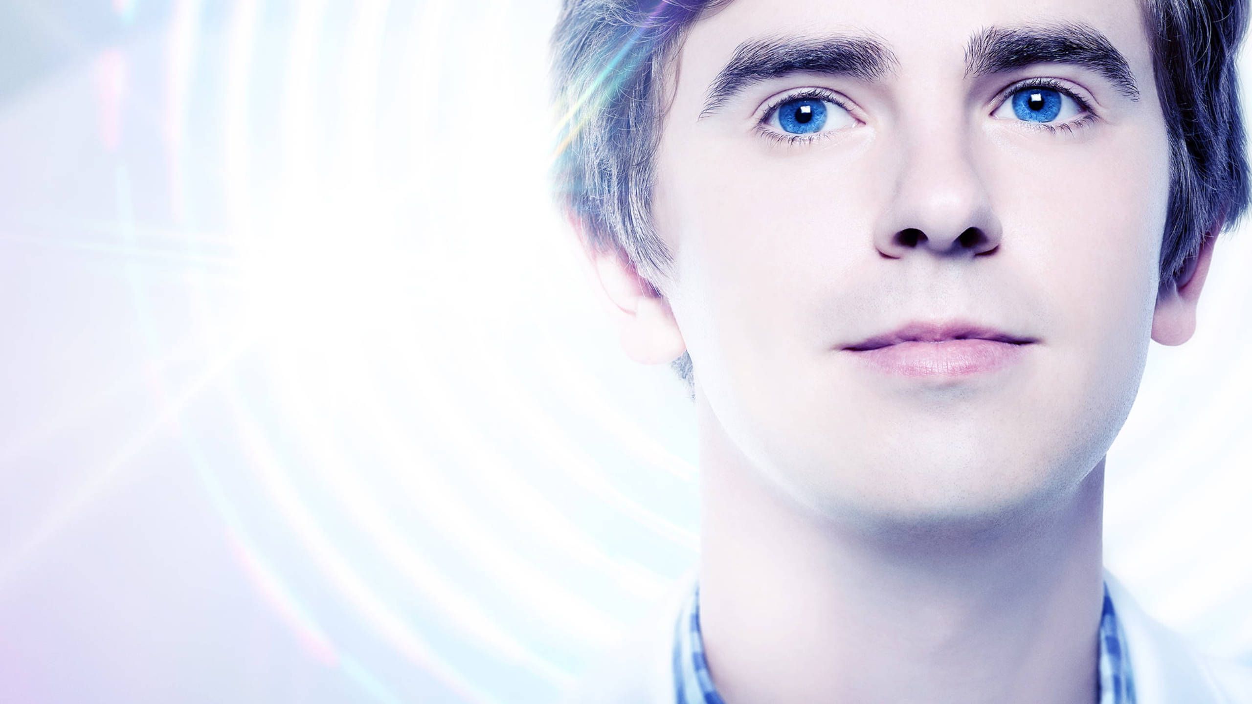 Freddie Highmore, blue eyes, glowing abstract light background, 2K Desktop Wallpaper