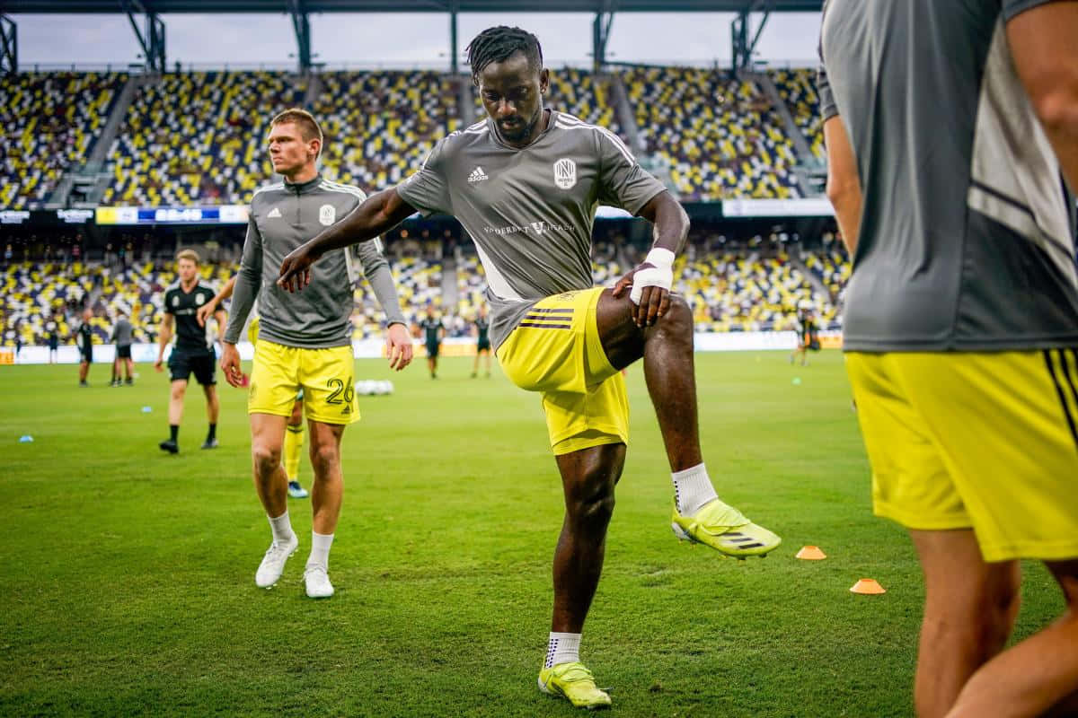 soccer player, gray and yellow gear, vibrant green field, SD Desktop Wallpaper