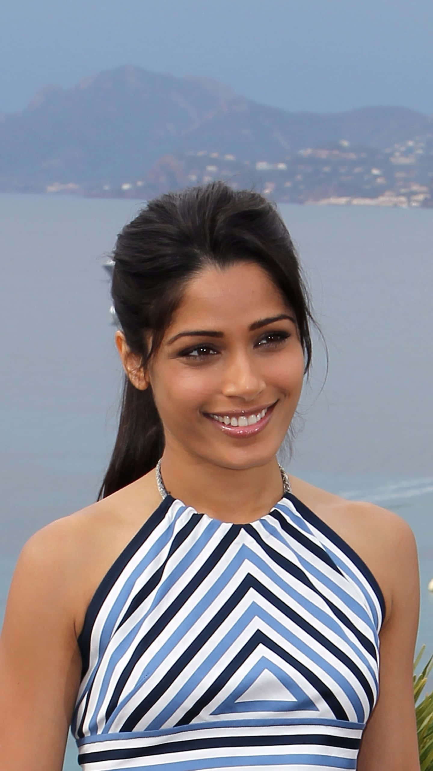 Freida Pinto, blue and white striped halter dress, calm sea, 2K Phone Wallpaper