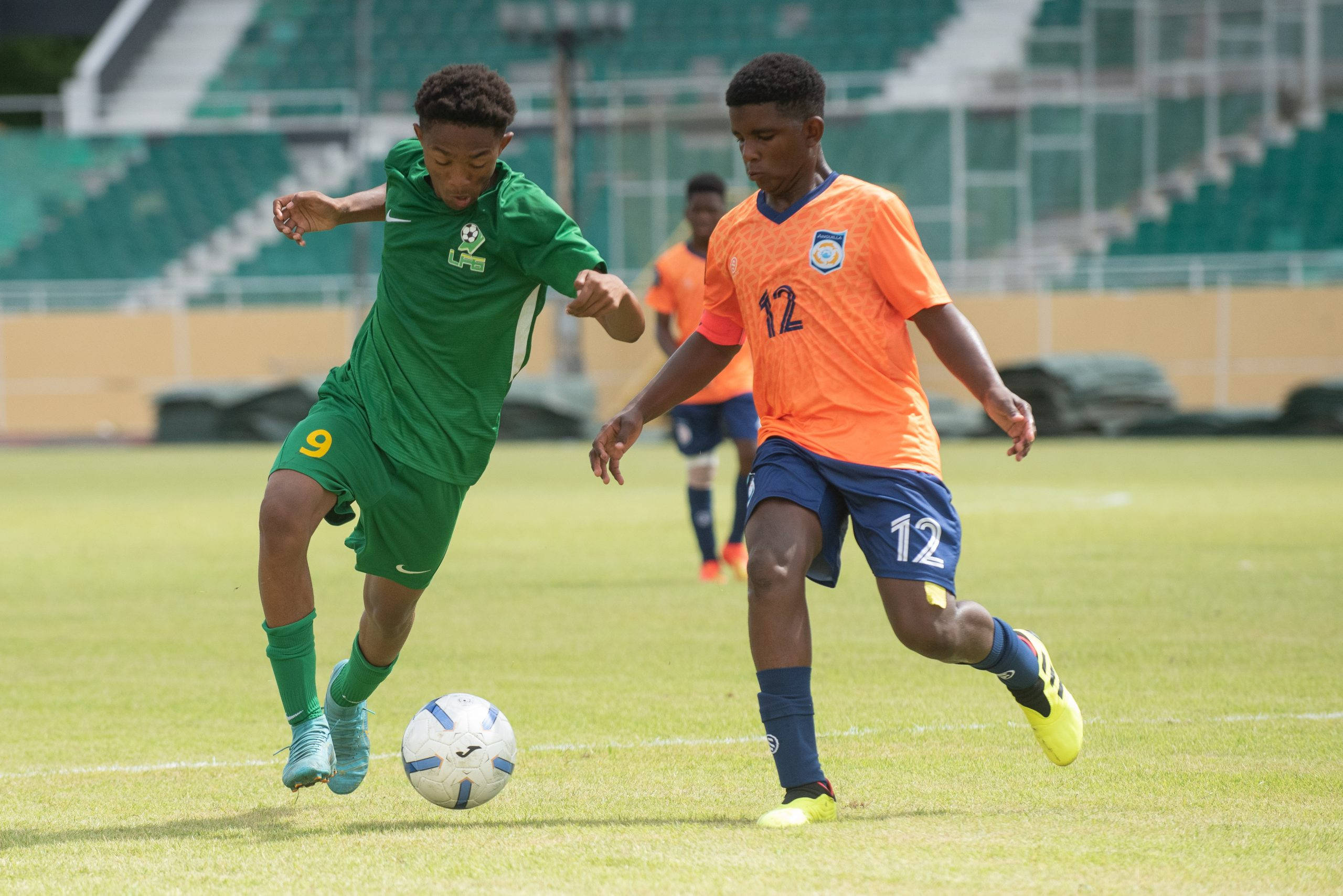 French Guiana, green and orange jerseys, sunlit grass field, 2K Desktop Wallpaper