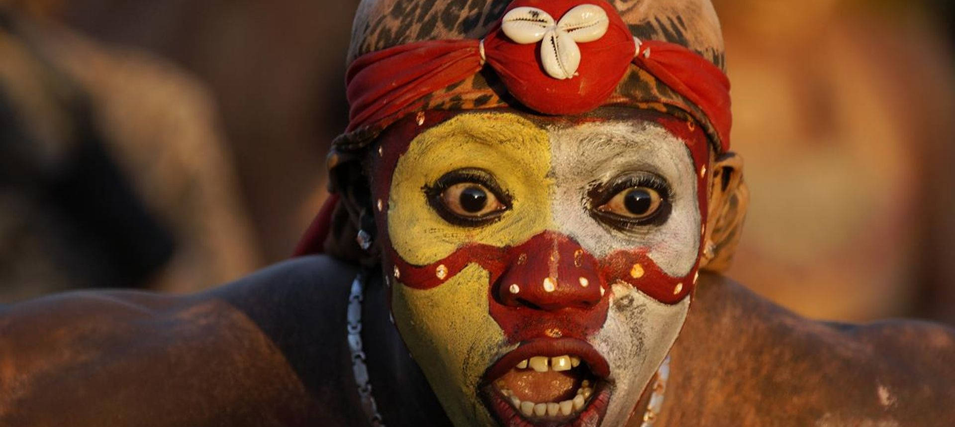 French Guiana, vibrant yellow red and white face paint, red headband, Full HD Desktop Wallpaper