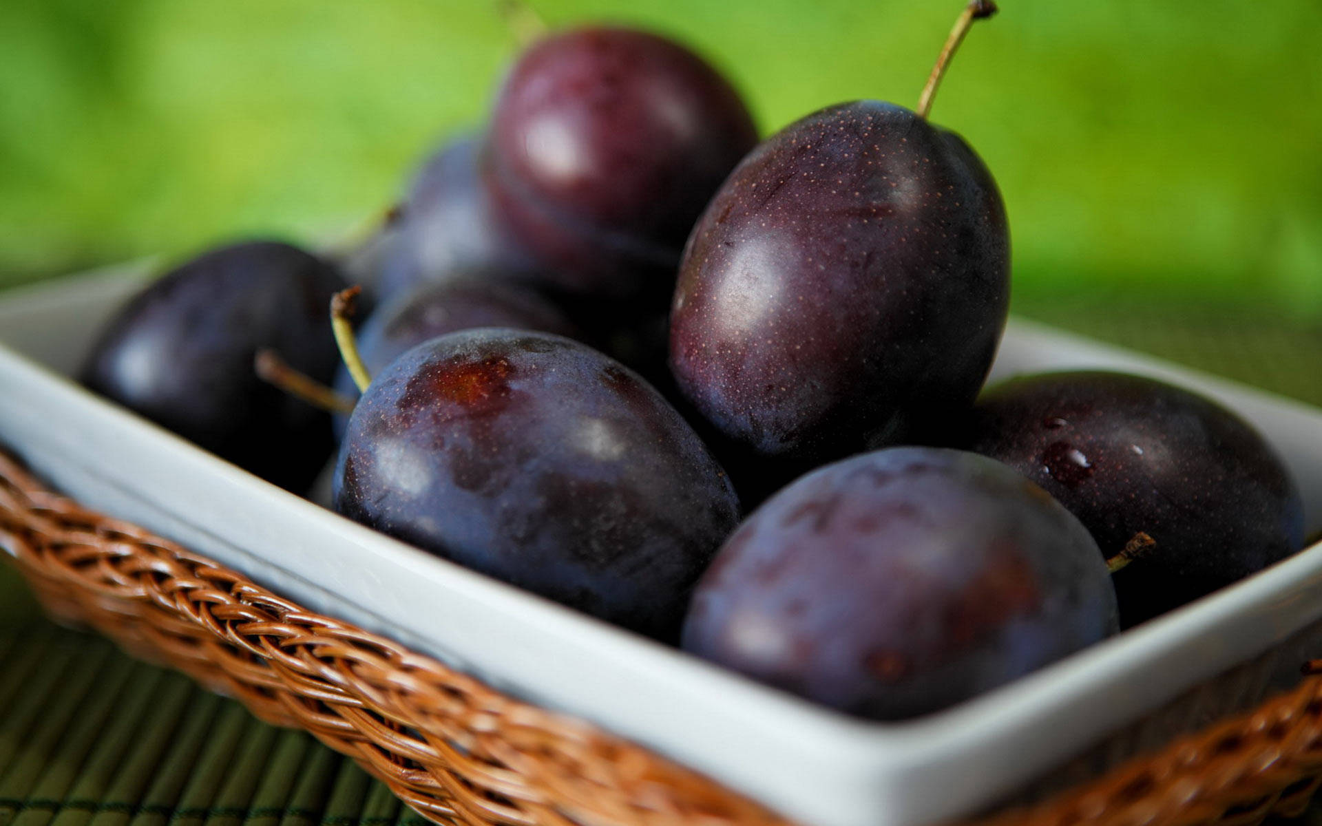 dark purple plums, white ceramic dish, woven wicker basket, Full HD Desktop Wallpaper