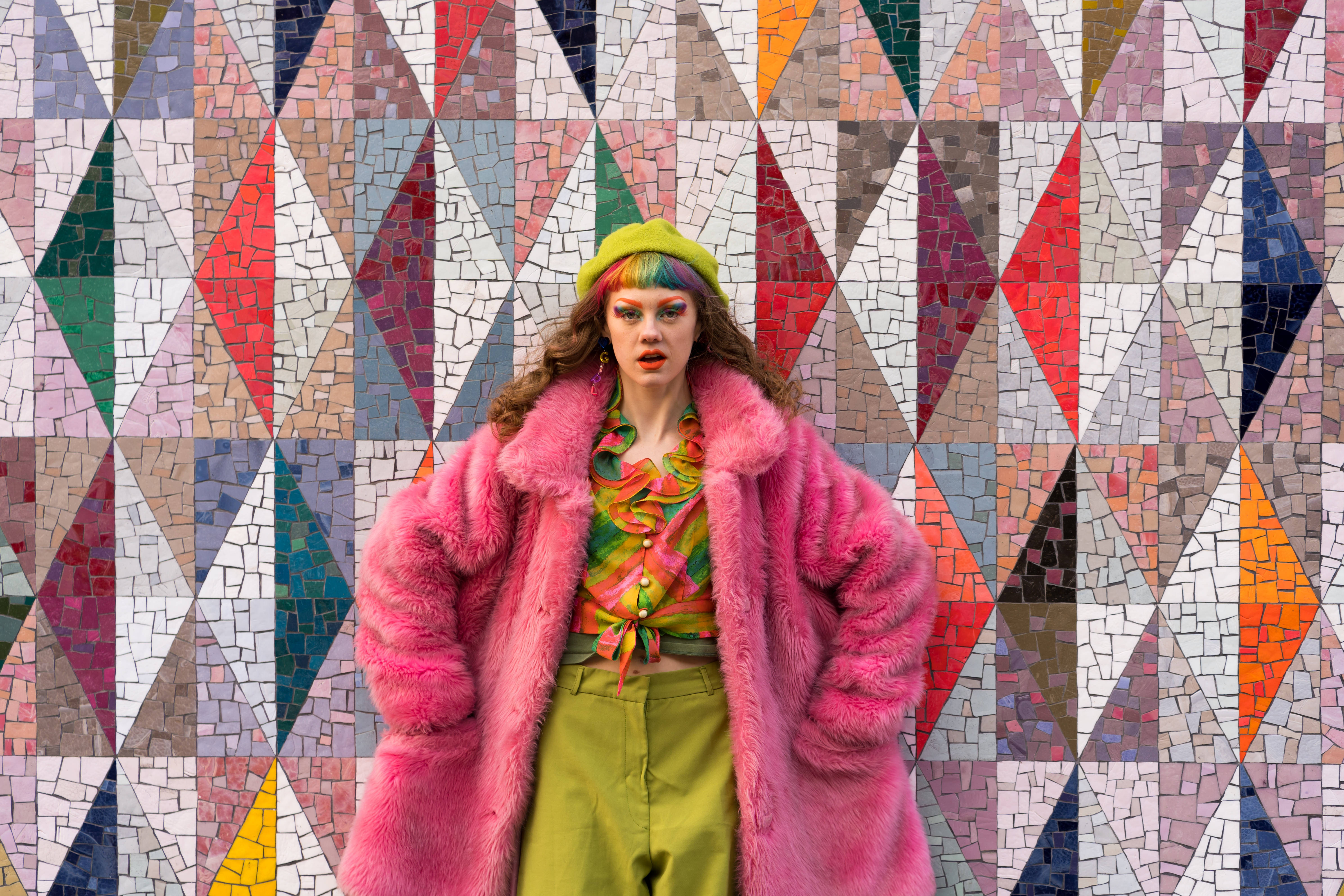 pink fur coat, green hat, vibrant geometric mosaic wall, 5K Desktop Wallpaper