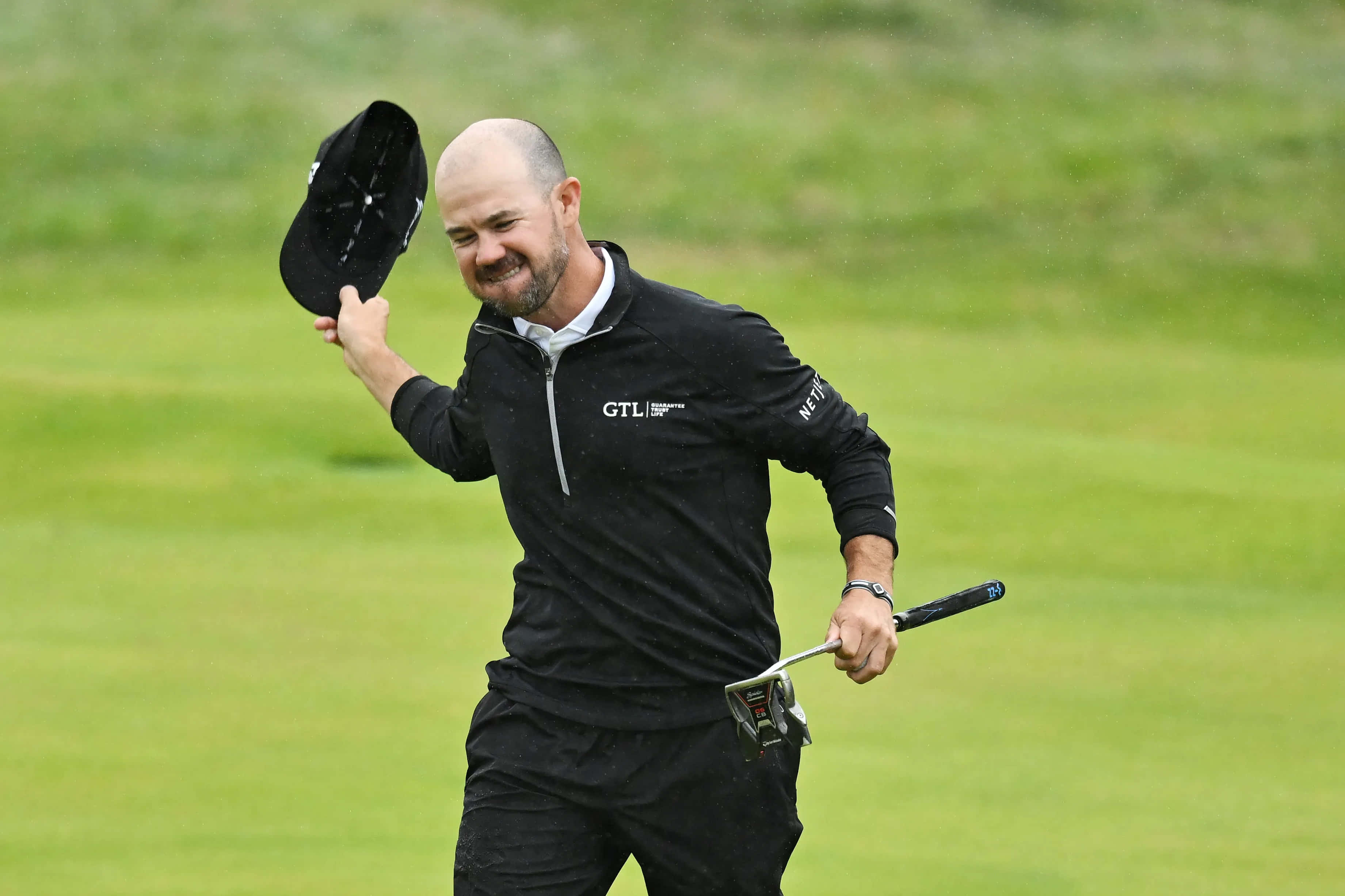 bald golfer, black attire, lush green course, 2K Desktop Wallpaper