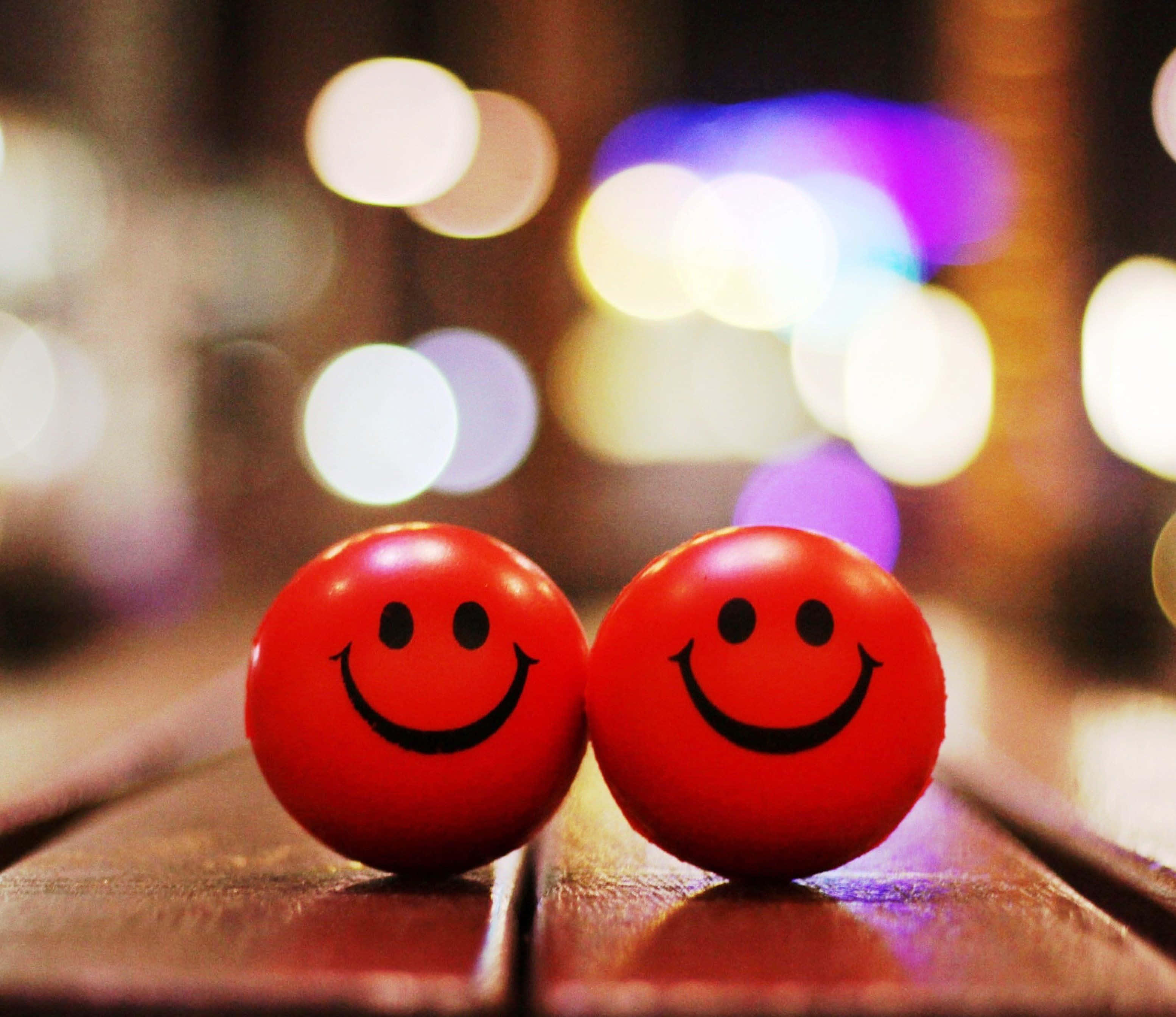 red smiley face balls, wooden surface, colorful bokeh lights, 2K Desktop Wallpaper