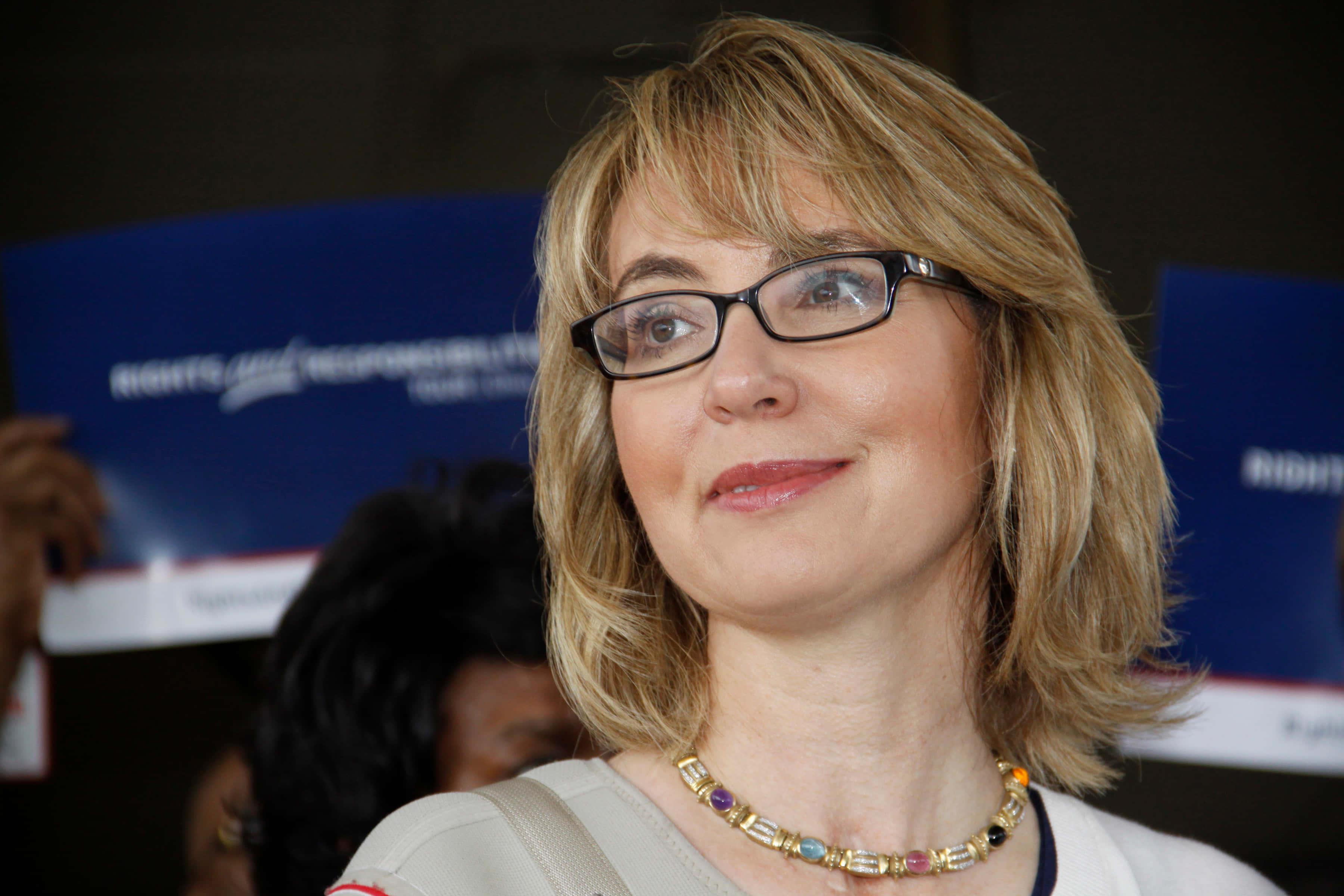 Gabrielle Giffords, blue signs, beaded necklace, 2K Desktop Wallpaper