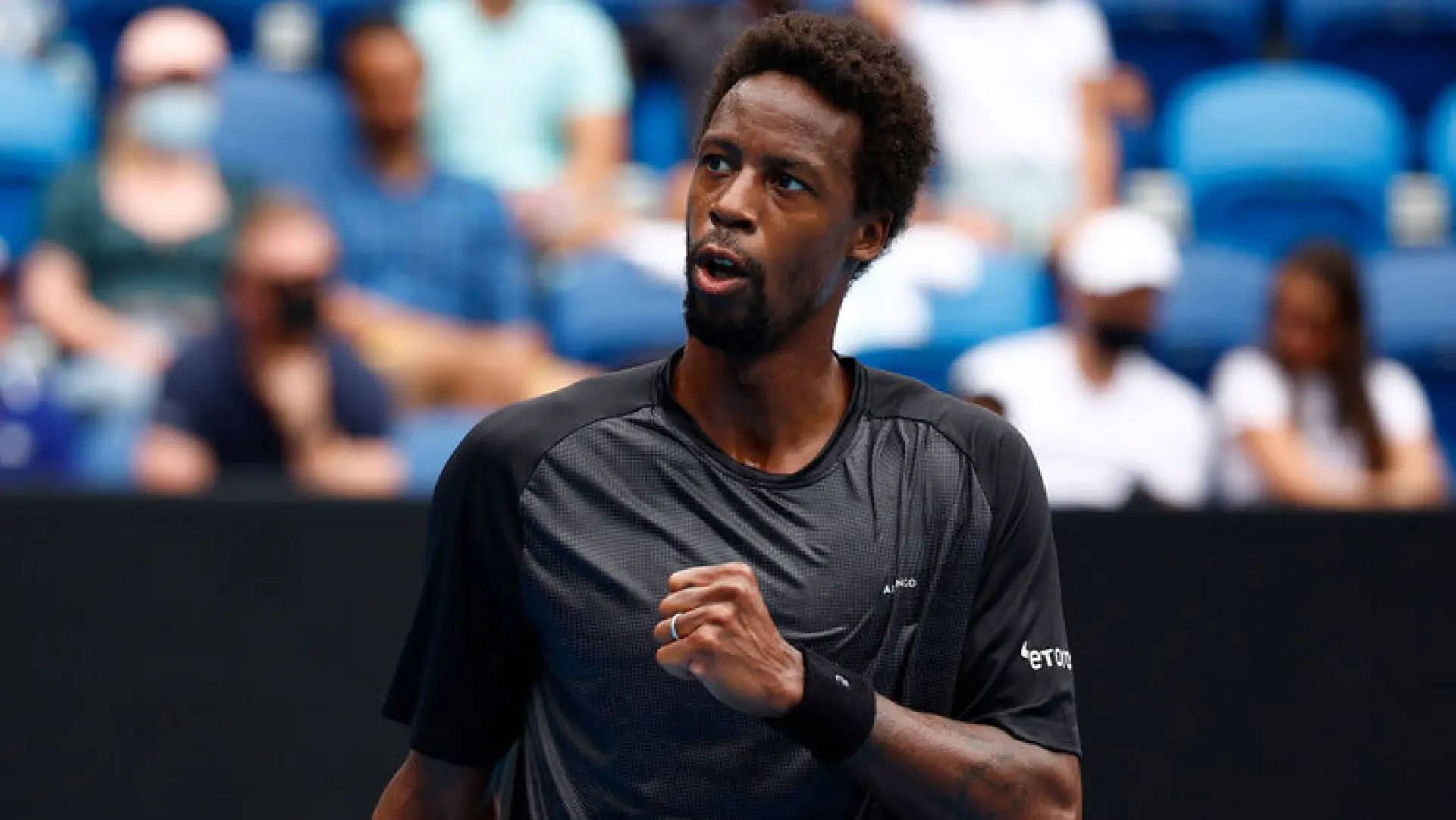 Gael Monfils, black athletic shirt, blurred in blue stadium seats, Full HD Desktop Wallpaper