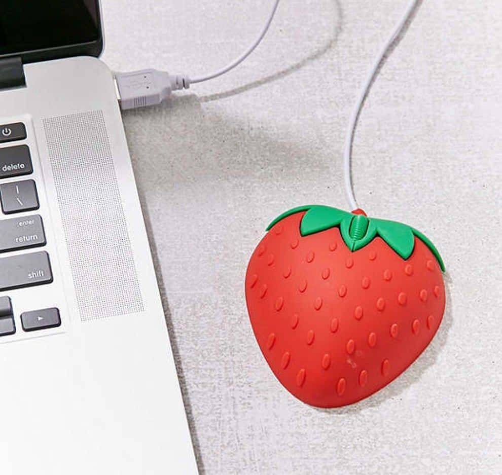 red strawberry-shaped USB mouse, silver laptop, light gray textured surface, SD Desktop Wallpaper