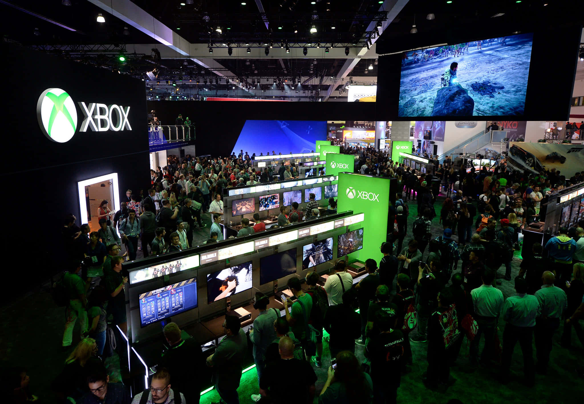 Xbox gaming stations, glowing green lights, bustling convention hall, Full HD Desktop Wallpaper