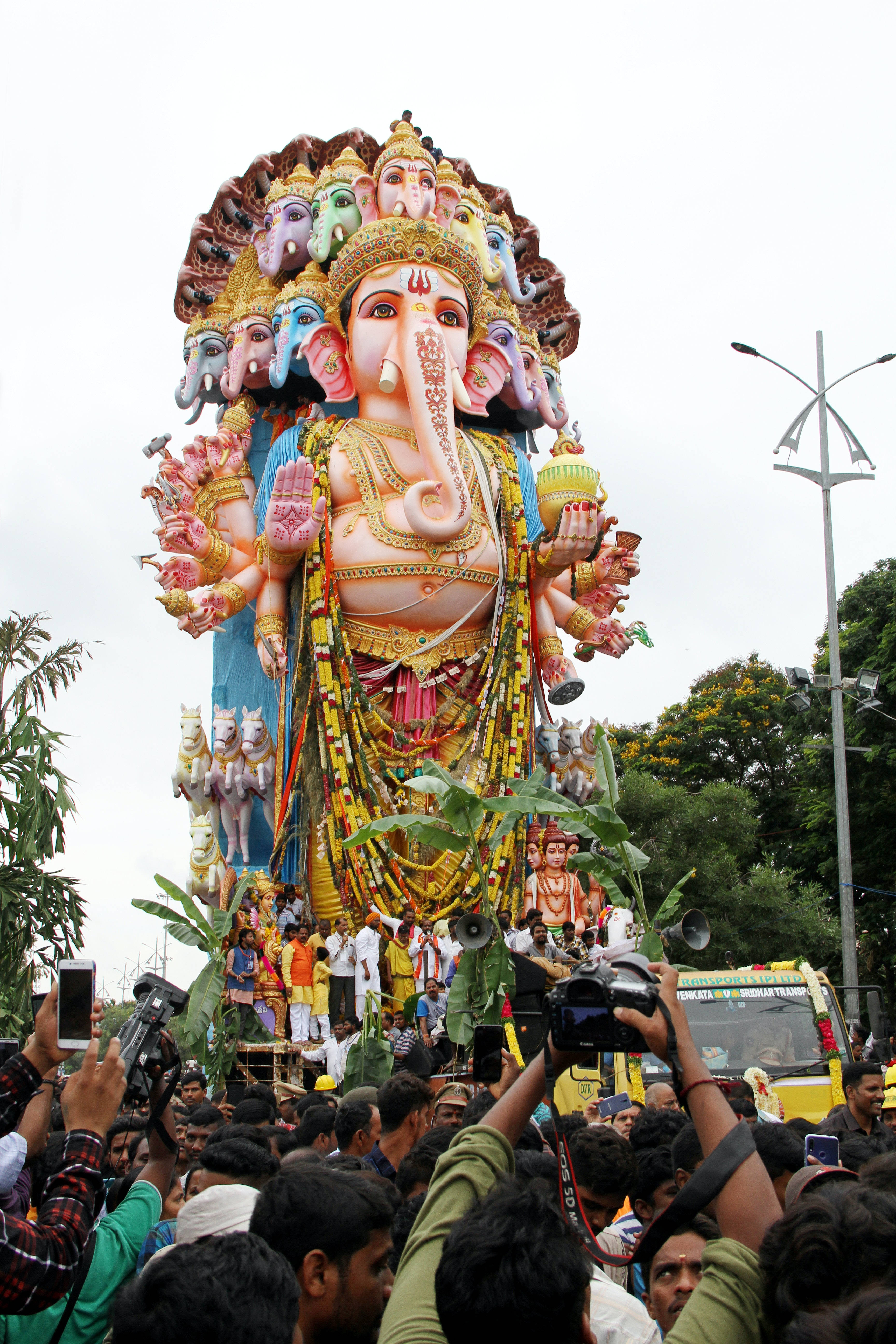 Ganesh Mobile, towering colorful Ganesha idol, multiple heads and arms, 5K Phone Wallpaper