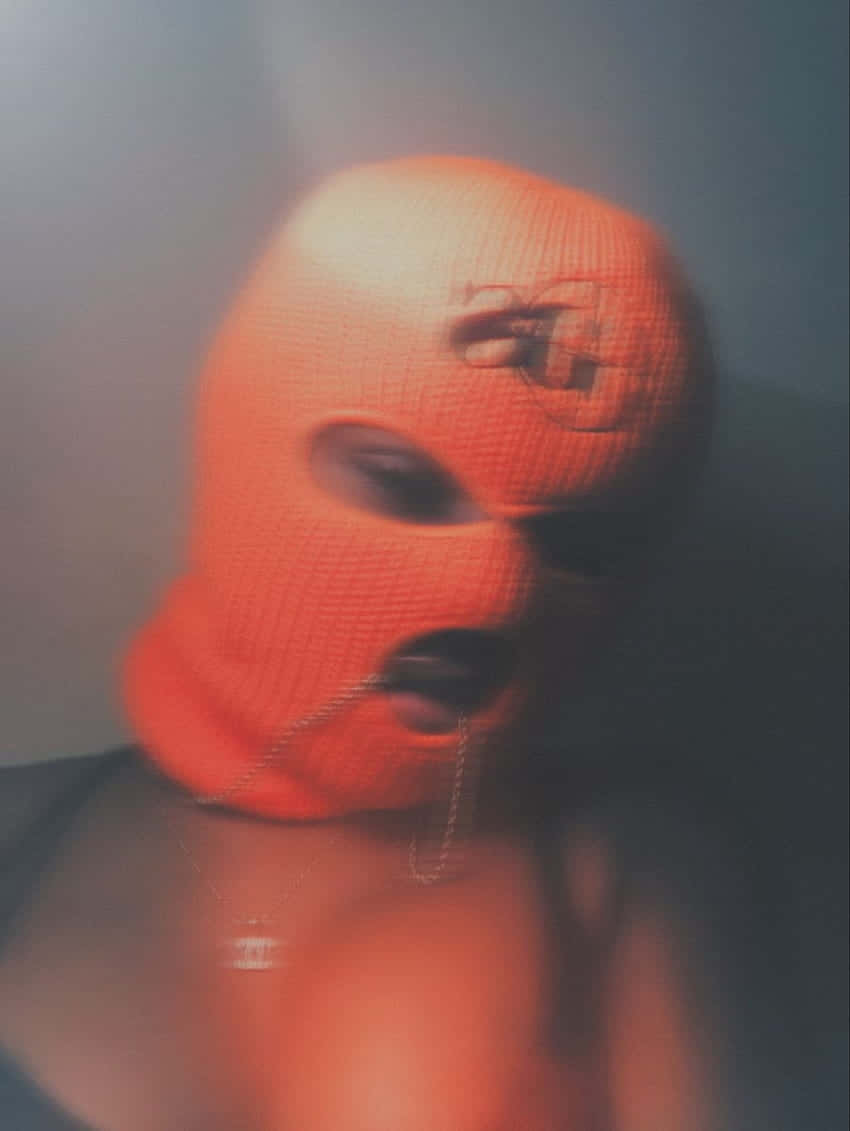 orange balaclava, chain dangling from the mouth, hazy dim background, SD Phone Wallpaper