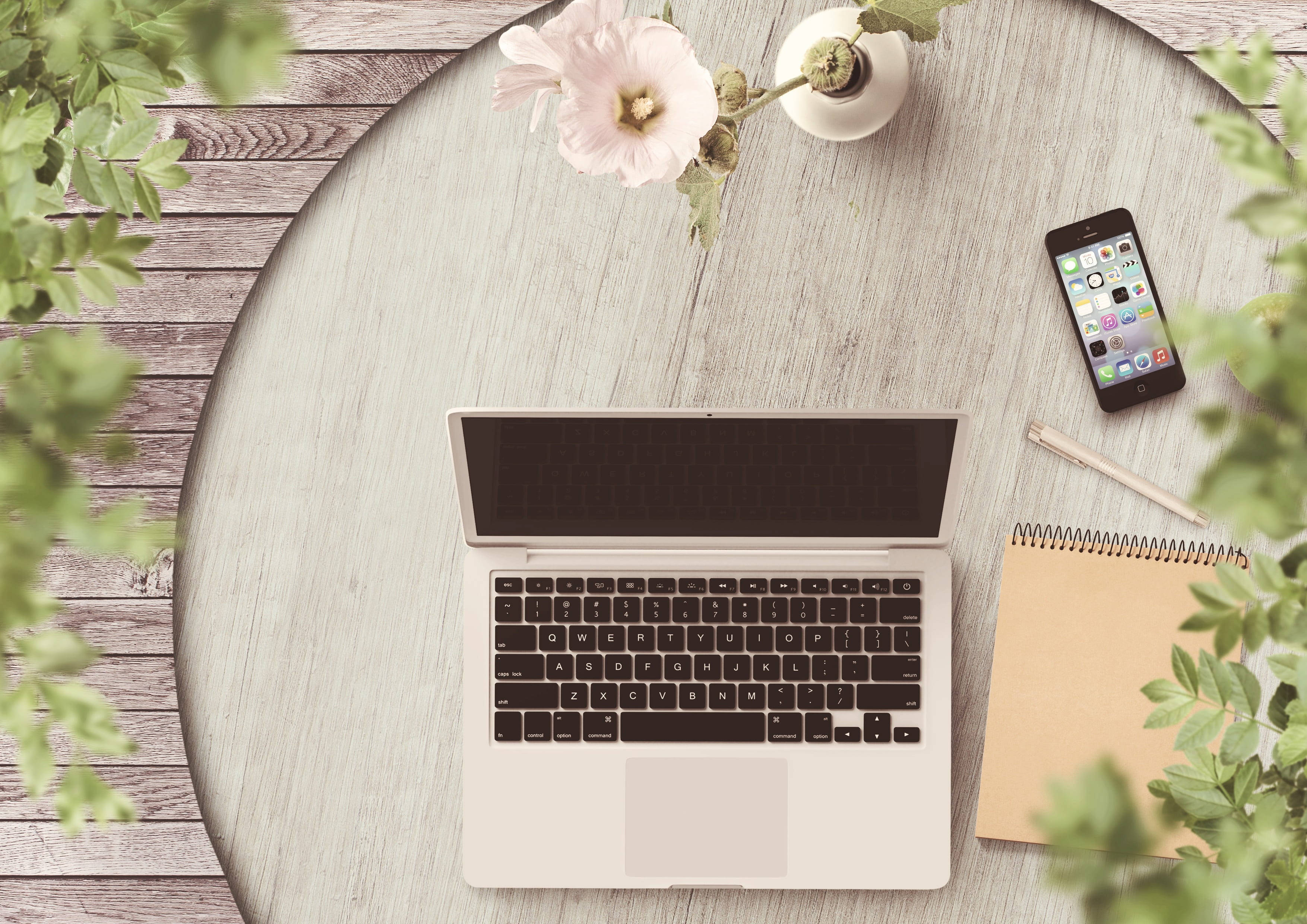 silver laptop, round wooden table, greenery, 2K Desktop Wallpaper