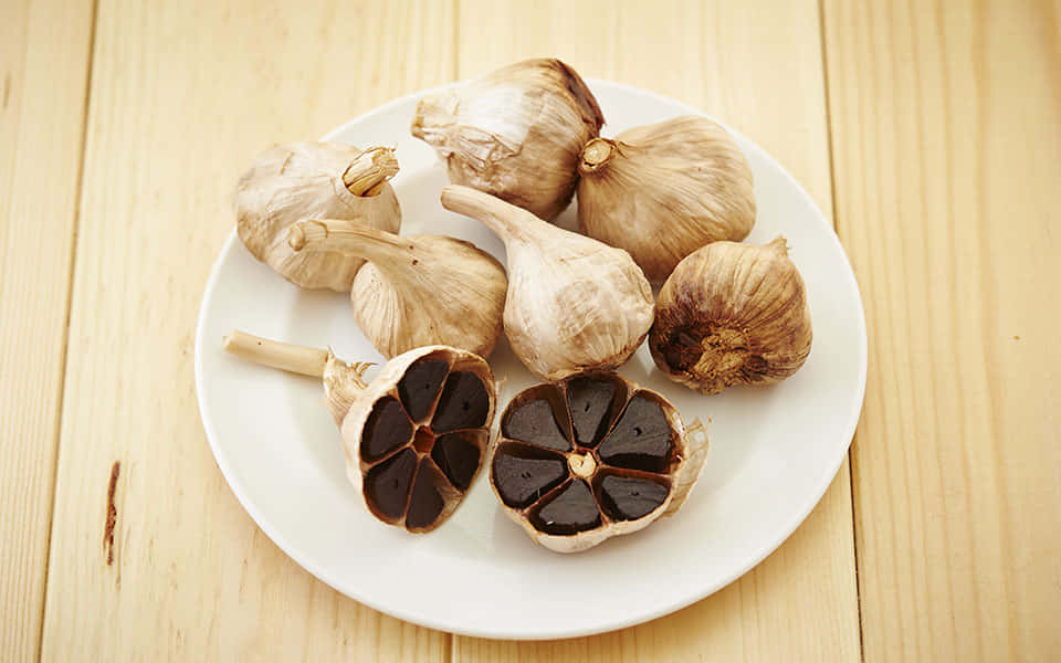 black garlic, white plate, whole garlic bulbs, SD Desktop Wallpaper