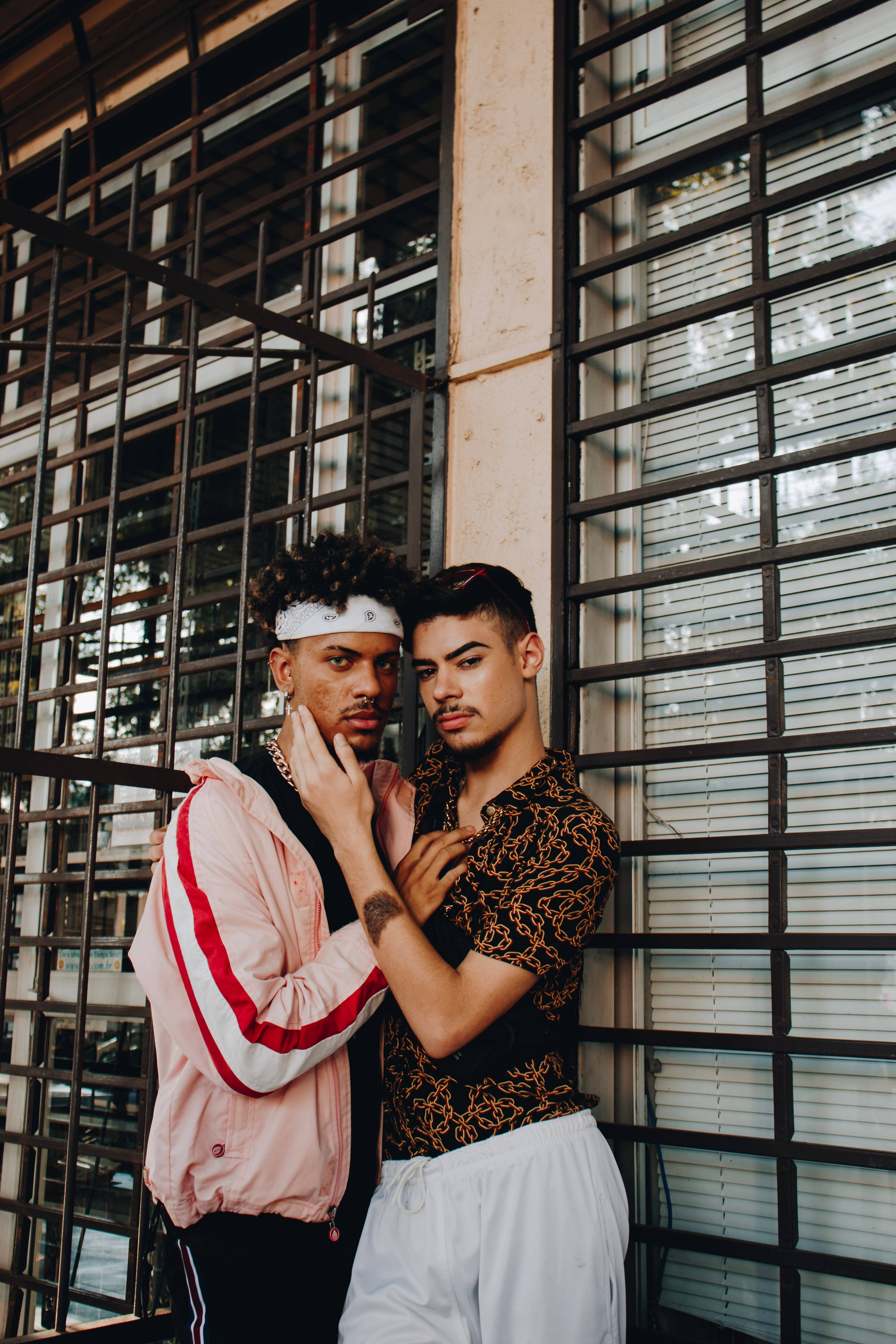 Gay Men By Windows, metal-grated urban wall, soft natural light, 5K Phone Wallpaper