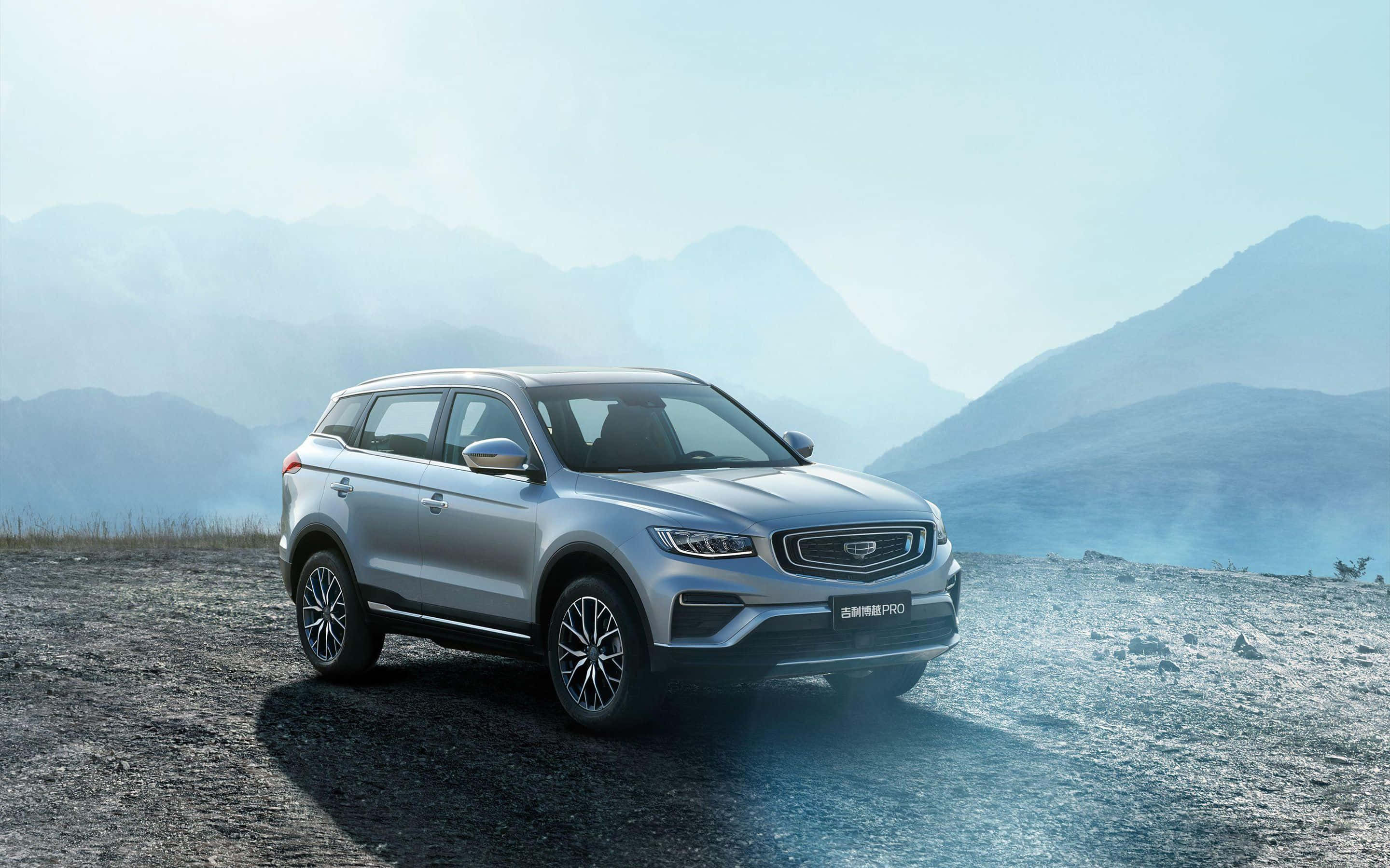 Geely, sleek silver SUV, rugged mountain overlook, 2K Desktop Wallpaper