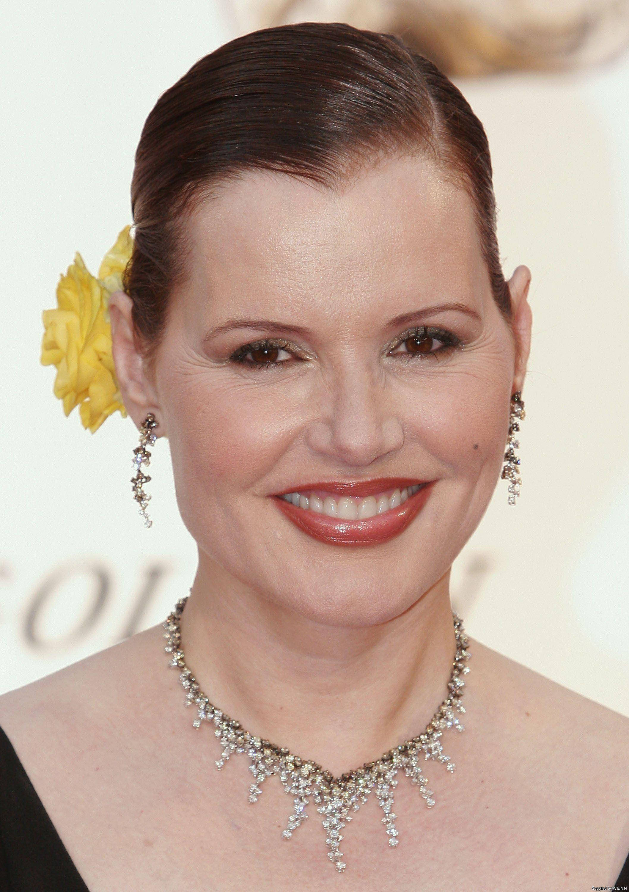 Geena Davis, slicked-back hair, yellow flower, 2K Phone Wallpaper