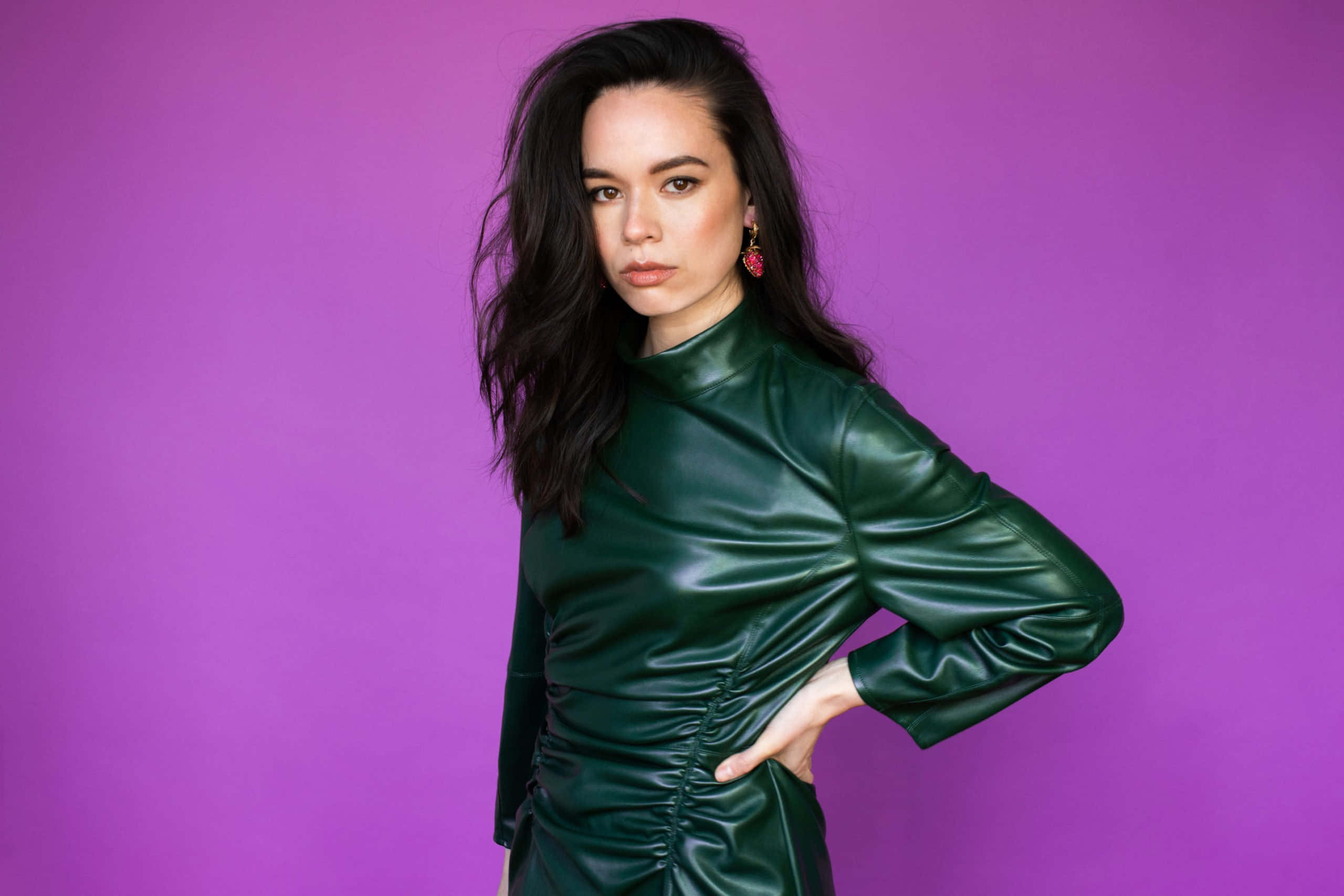 Genevieve Kang, shiny green dress, vibrant purple studio background, 2K Desktop Wallpaper
