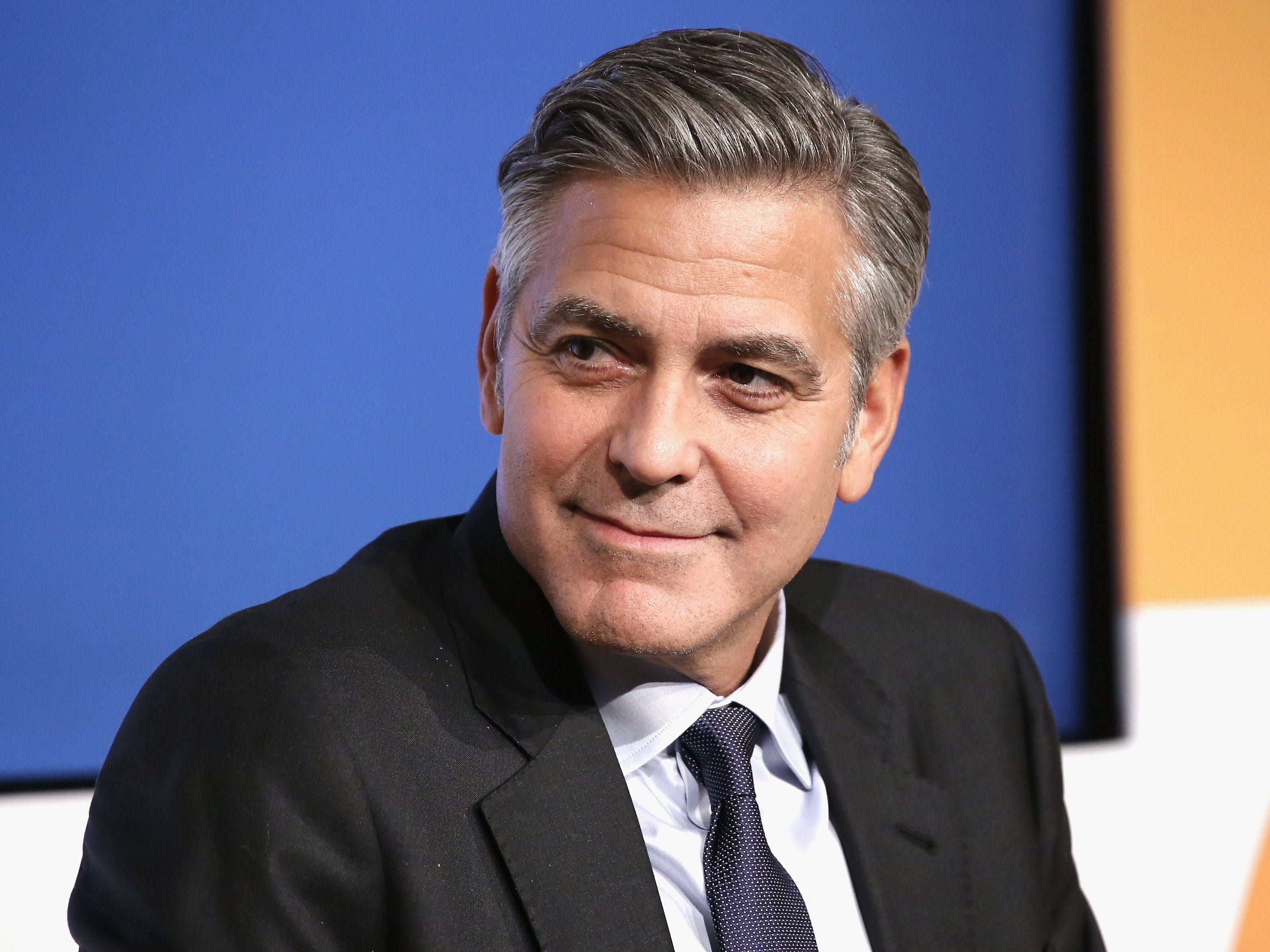 George Clooney, black suit, blue and orange backdrop, 2K Desktop Wallpaper