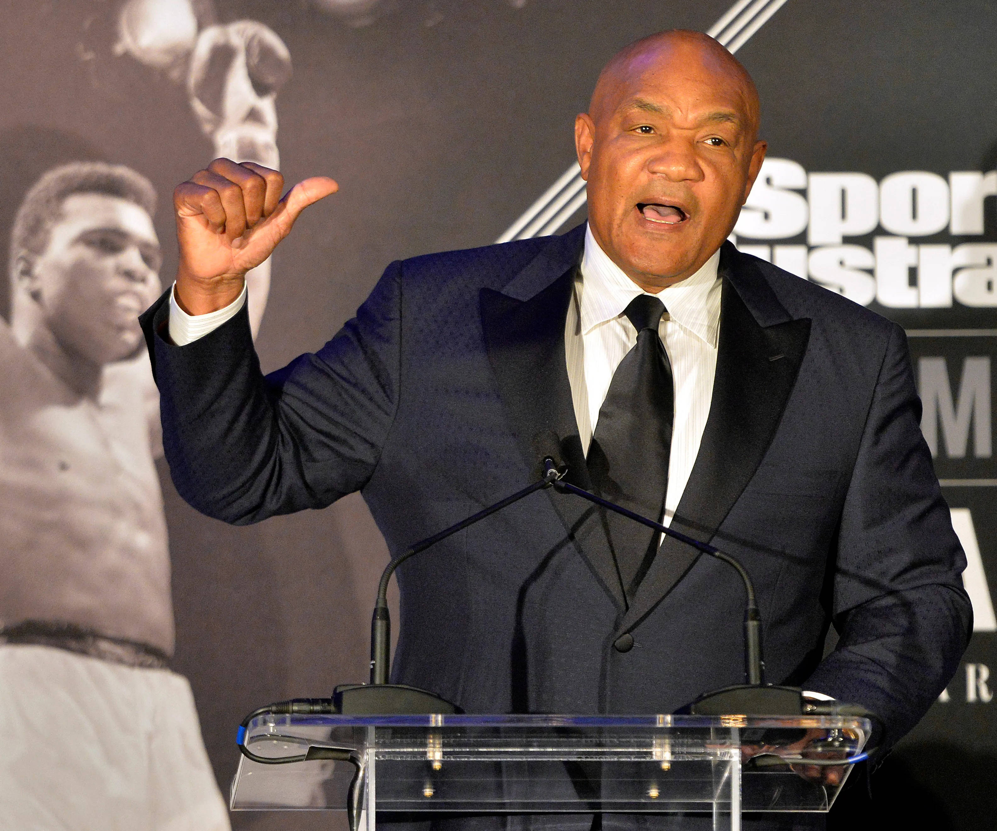 George Foreman, dark suit, clear podium, 2K Desktop Wallpaper