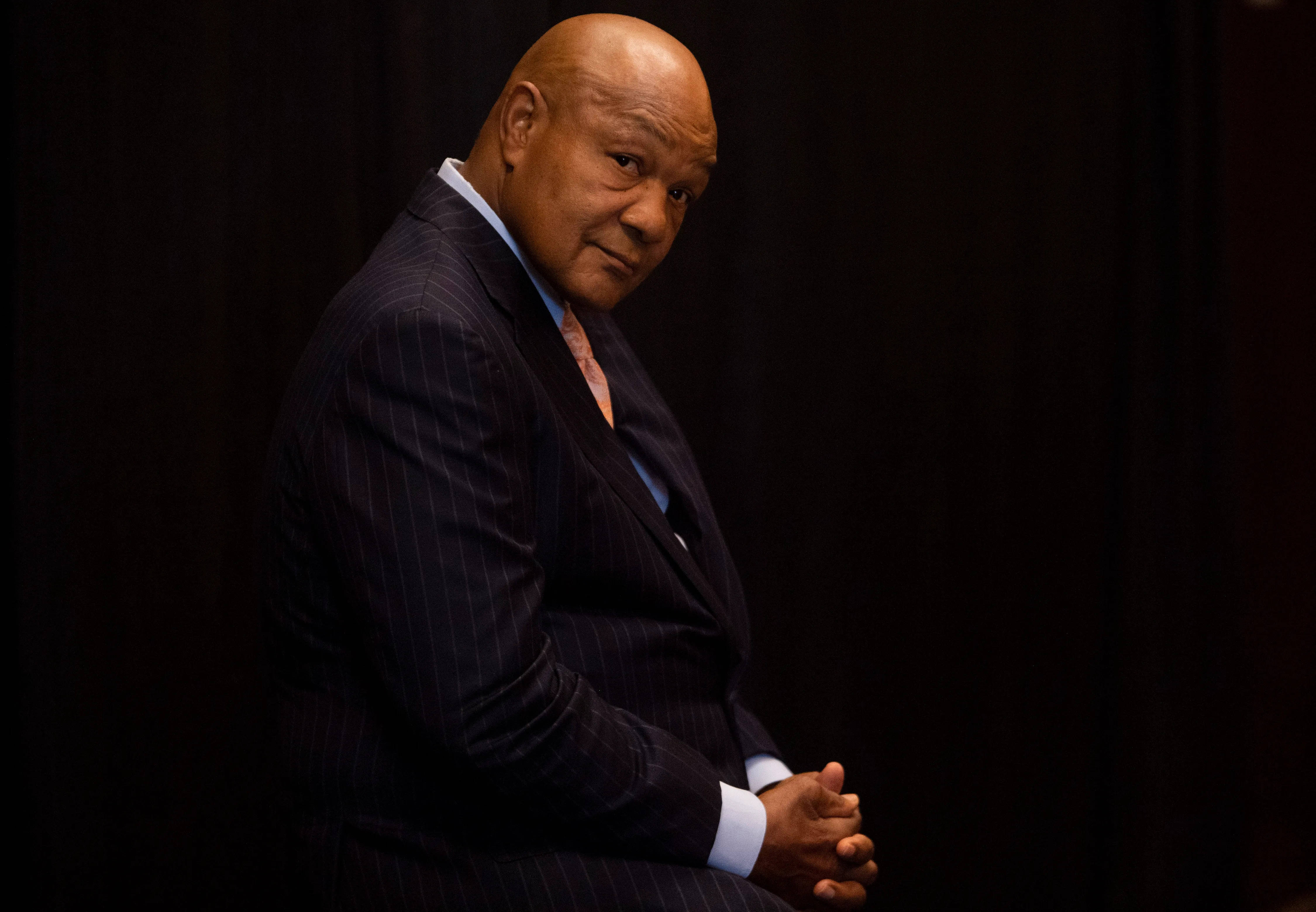 George Foreman, dark pinstripe suit, black backdrop, 4K Desktop Wallpaper