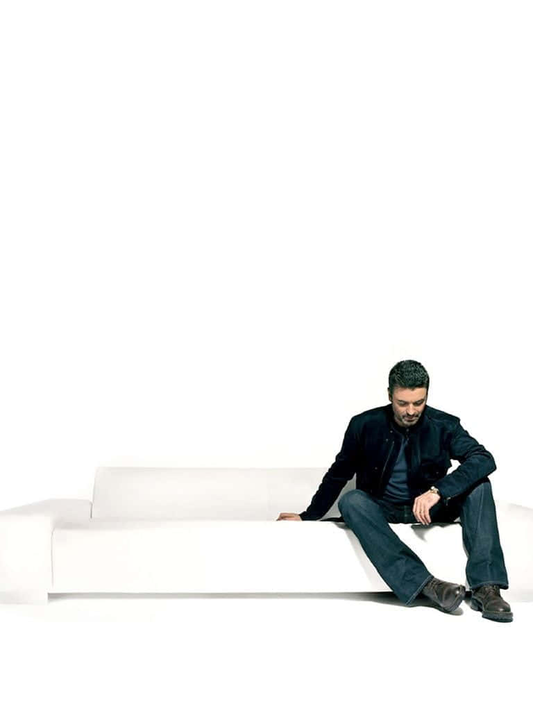 George Michael, dark clothing, sleek white sofa, SD Phone Wallpaper