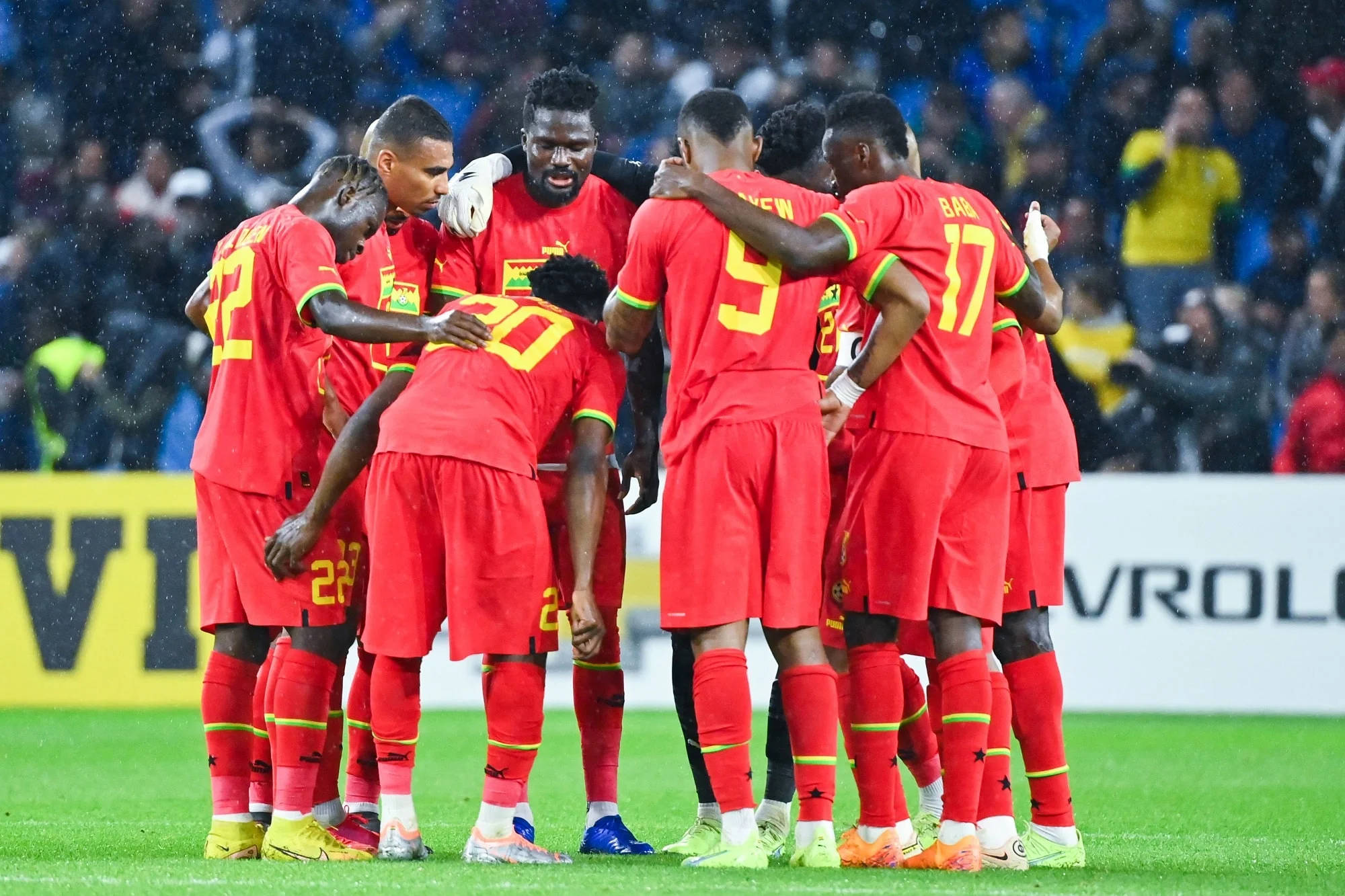Ghana National Football Team, red jerseys, rain-slicked field, Full HD Desktop Wallpaper