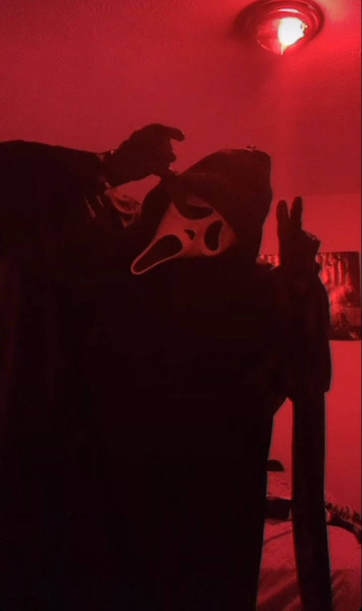 Ghostface mask, dim red-lit room, peace sign, SD Phone Wallpaper