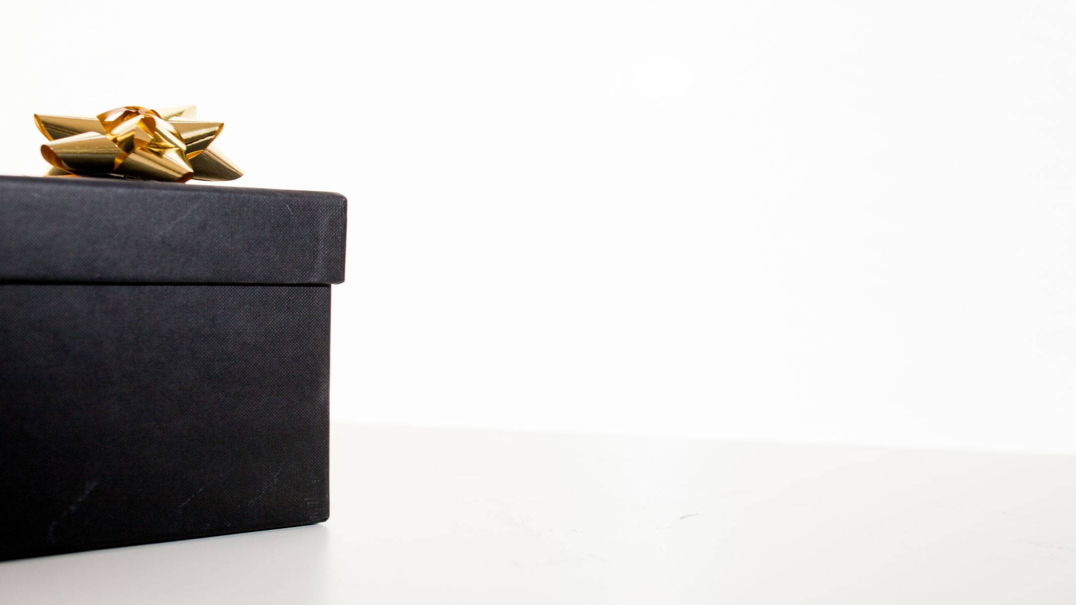 black gift box, shiny gold bow, pristine white surface, Full HD Desktop Wallpaper