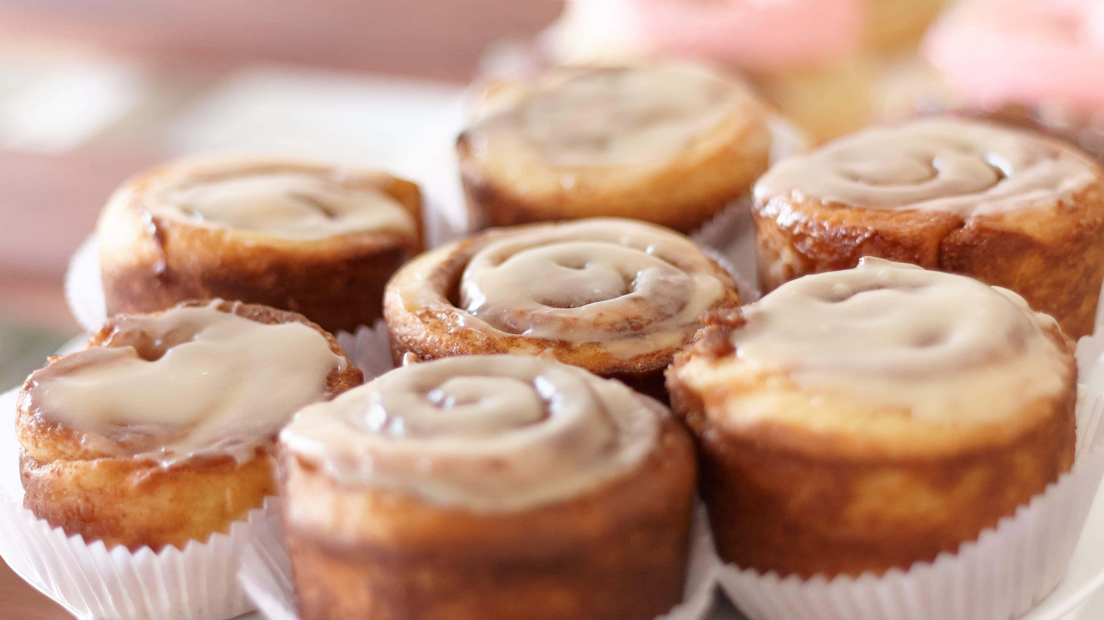 cinnamon rolls, creamy glaze, white paper liners, 2K Desktop Wallpaper