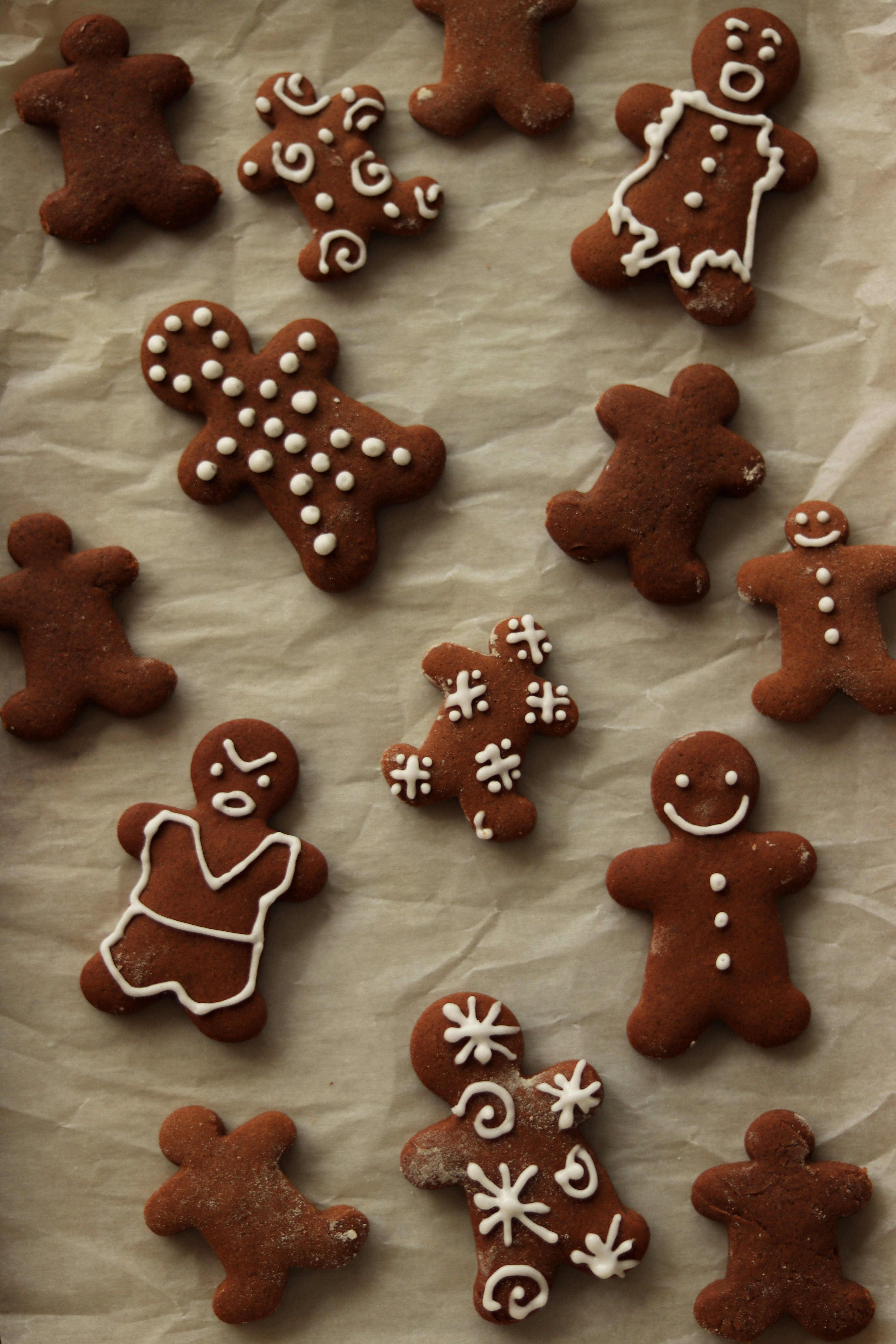 chocolate gingerbread cookie men, white icing decorations, crinkled parchment paper, 5K Phone Wallpaper