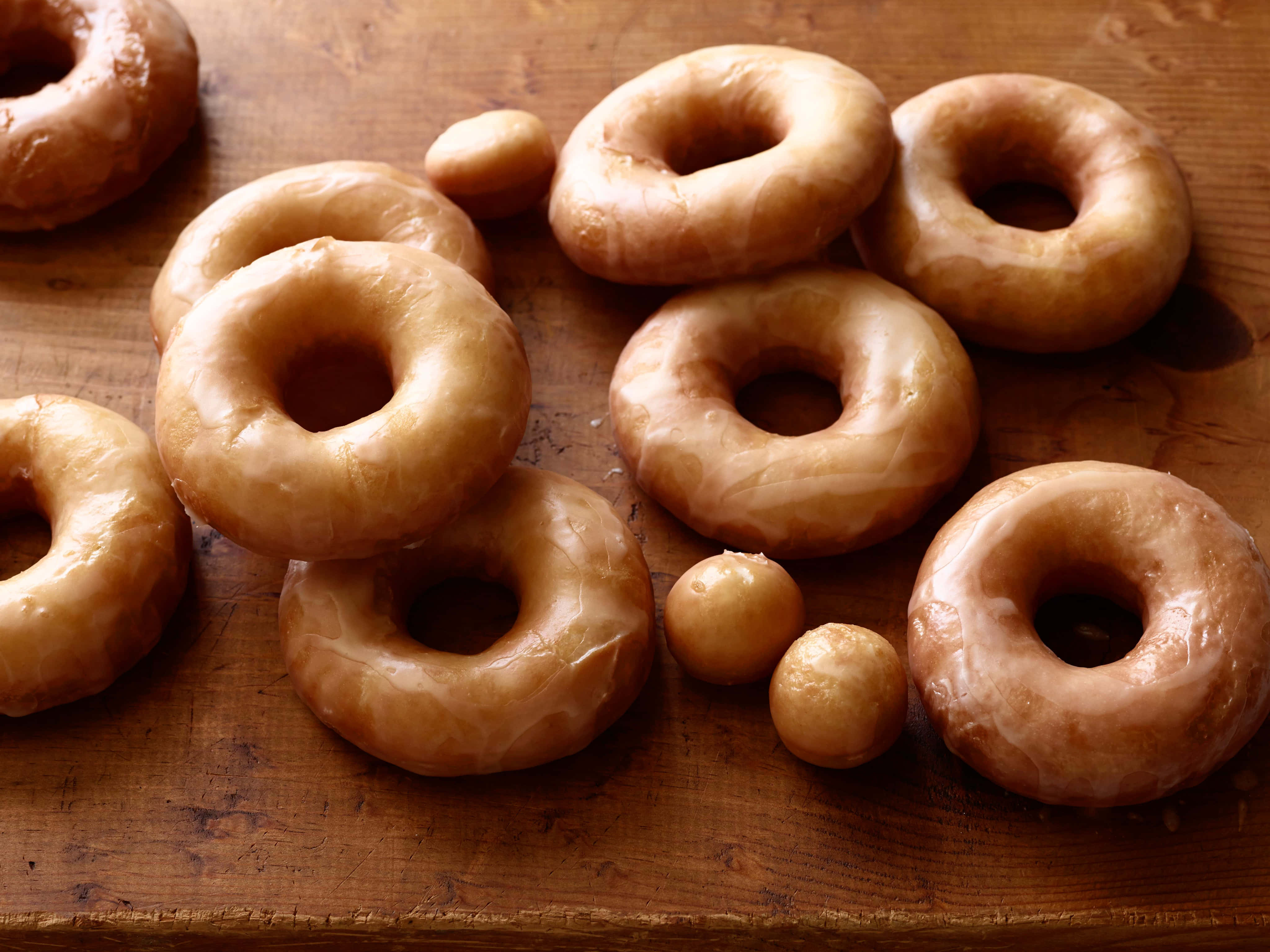 glazed donut, rustic wooden surface, warm lighting, 4K Desktop Wallpaper