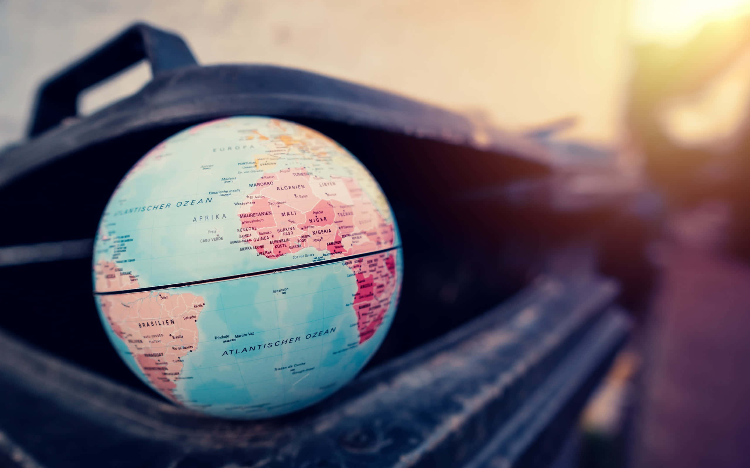 globe map, pink and blue continents, dark leather case, 2K Desktop Wallpaper