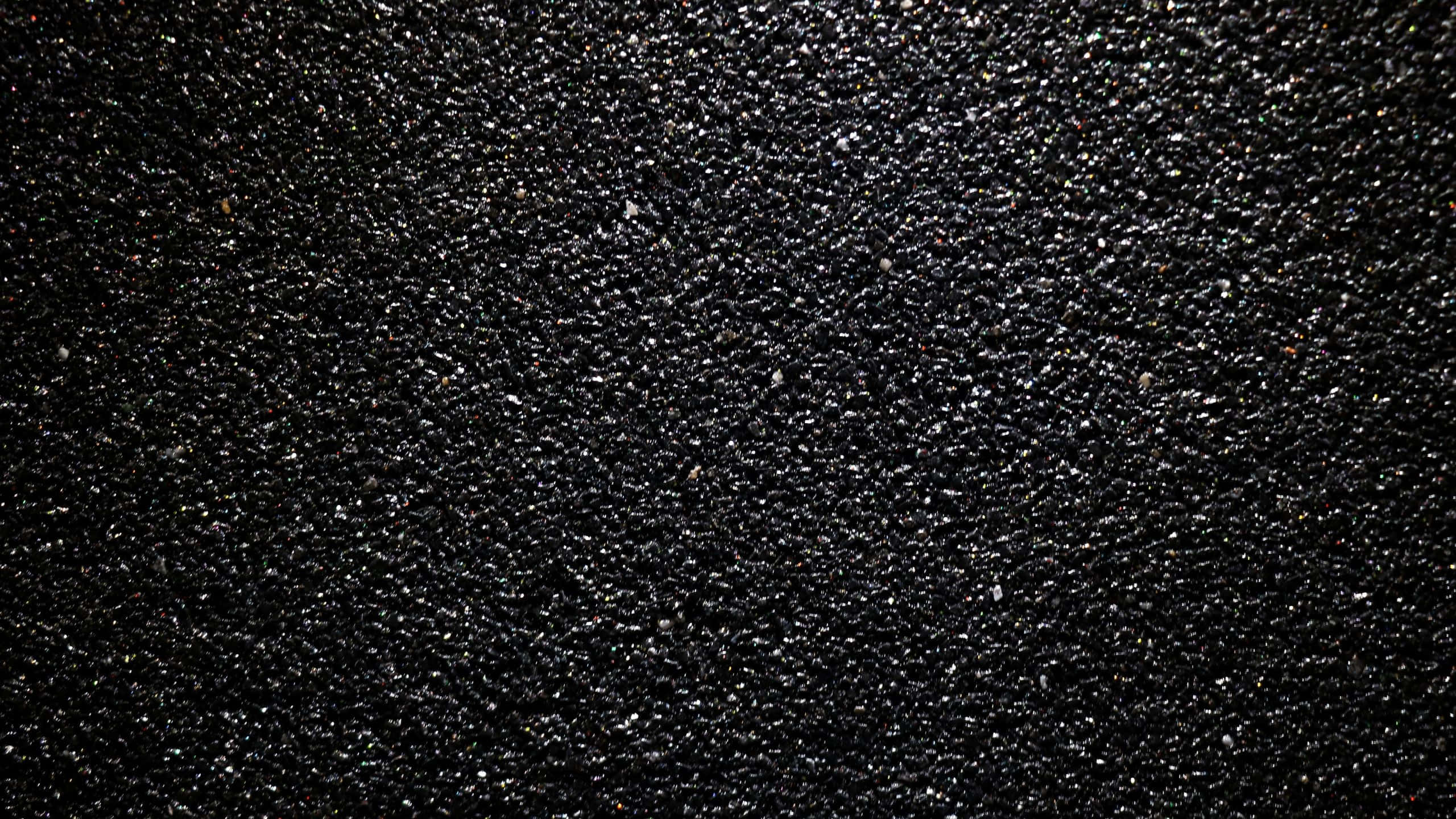 Glossy Black, dark textured surface, scattered tiny reflective specks, 2K Desktop Wallpaper