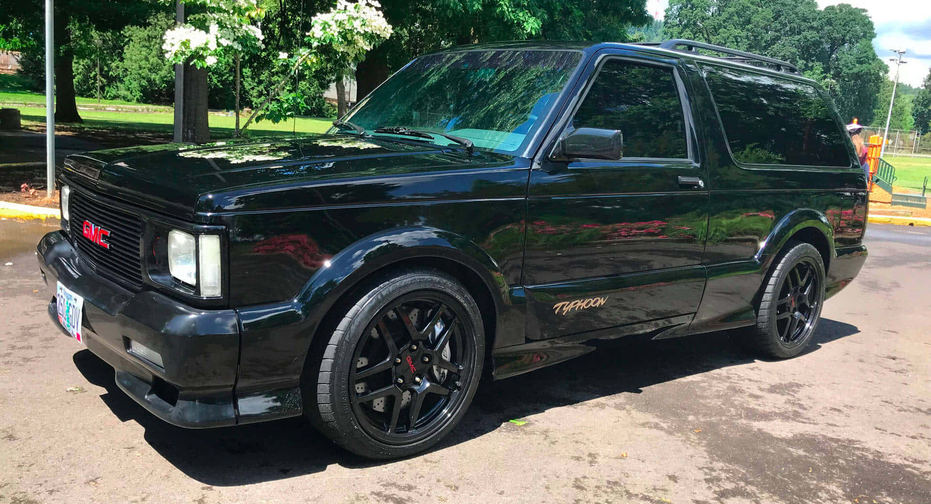 GMC Typhoon, glossy black, sunlit asphalt lot, Full HD Desktop Wallpaper