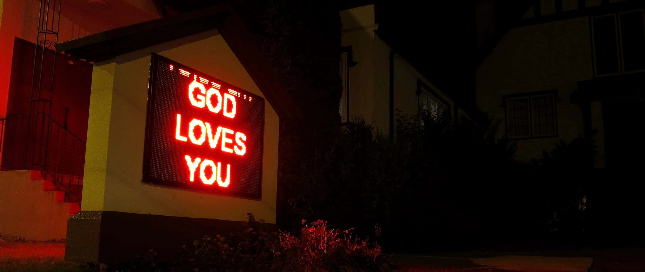 GOD LOVES YOU, glowing red LED sign, dark suburban house, 2K Desktop Wallpaper