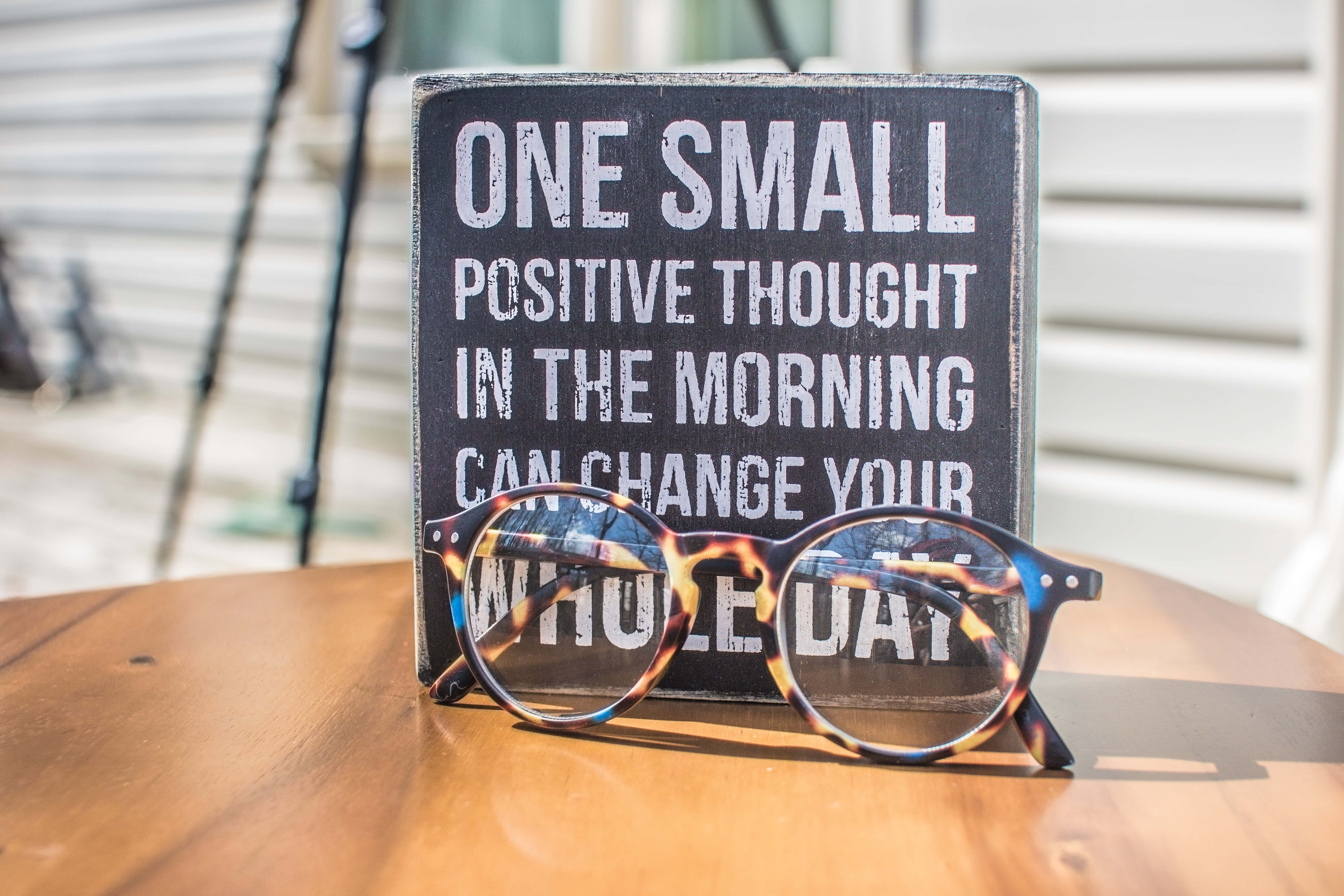Tortoiseshell glasses, wooden table, motivational sign, 5K Desktop Wallpaper