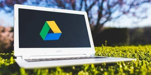 Google Drive logo, white laptop, vibrant green grass, SD Desktop Wallpaper