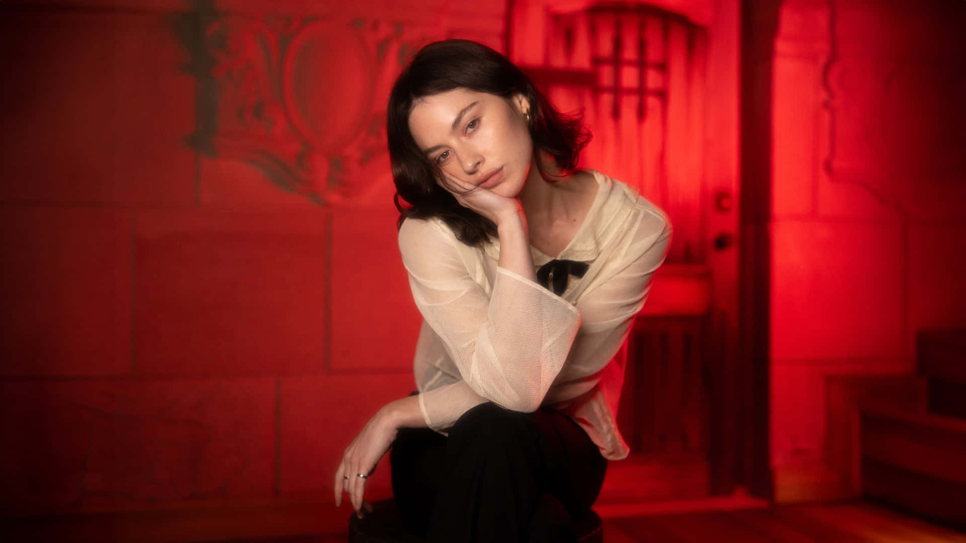 Gracie Abrams, red-lit room, ornate walls, Full HD Desktop Wallpaper