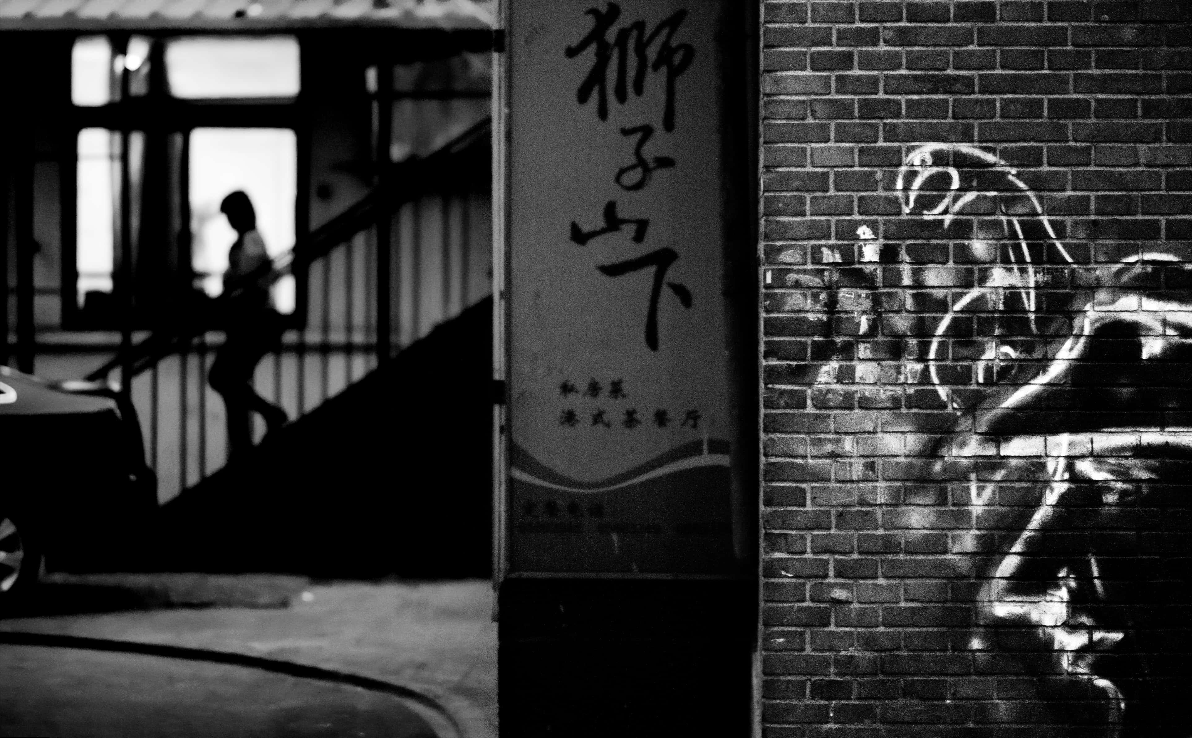 black and white urban scene, silhouetted person, brick wall, 4K Desktop Wallpaper