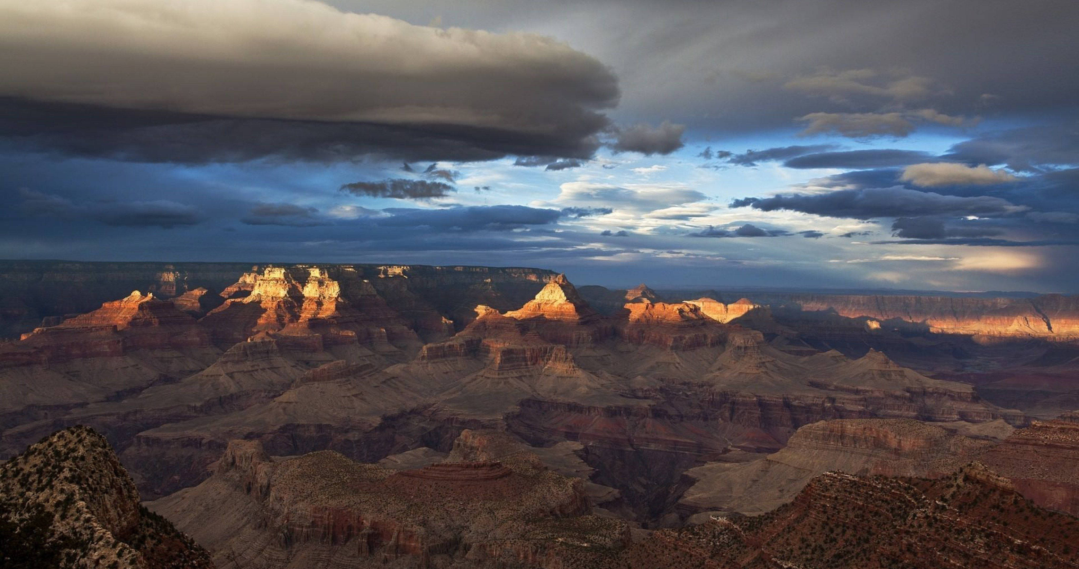 Grand Canyon, golden sunset light, brooding sky, 4K Desktop Wallpaper
