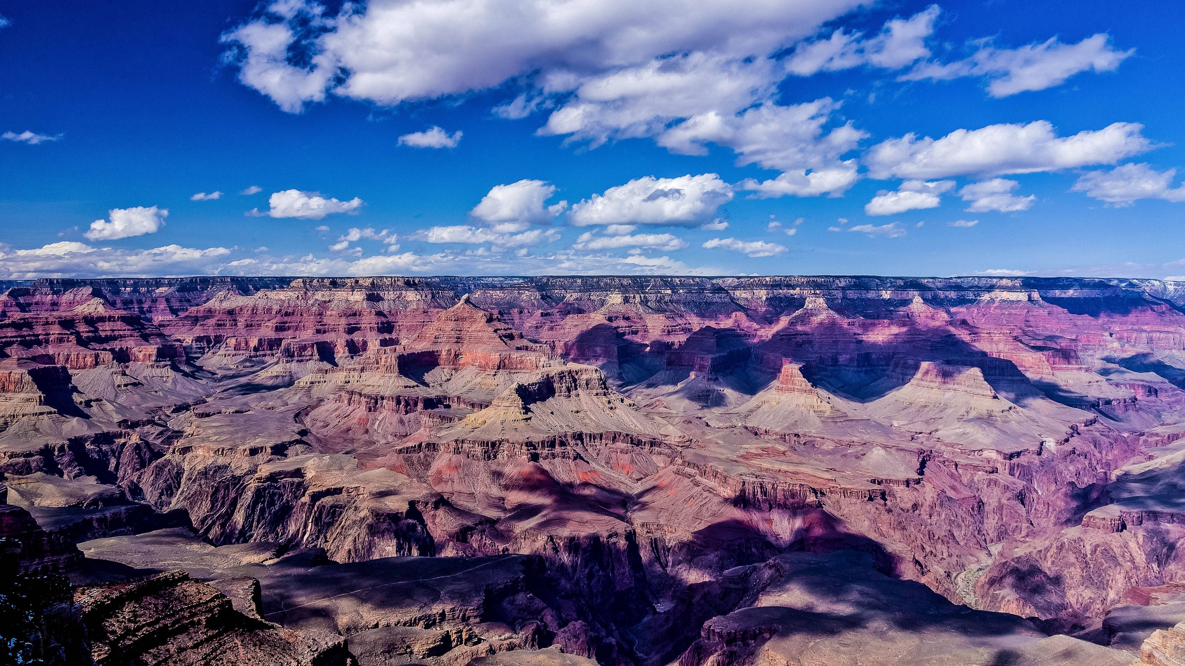 Grand Canyon, red rock formations, bright blue sky, 4K Desktop Wallpaper