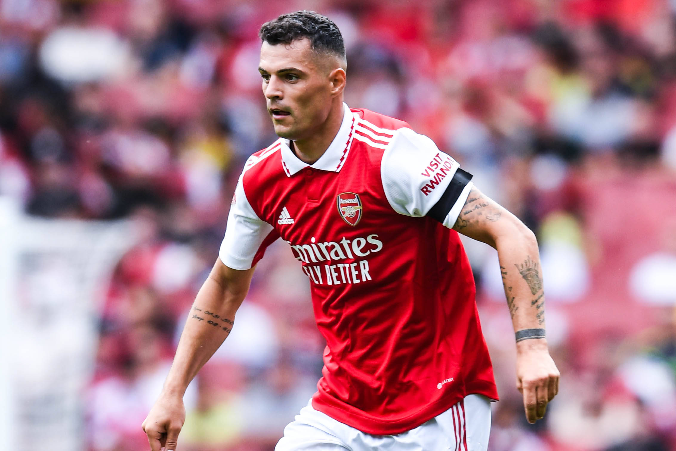 Granit Xhaka, red Arsenal jersey, sunlit pitch, Full HD Desktop Wallpaper