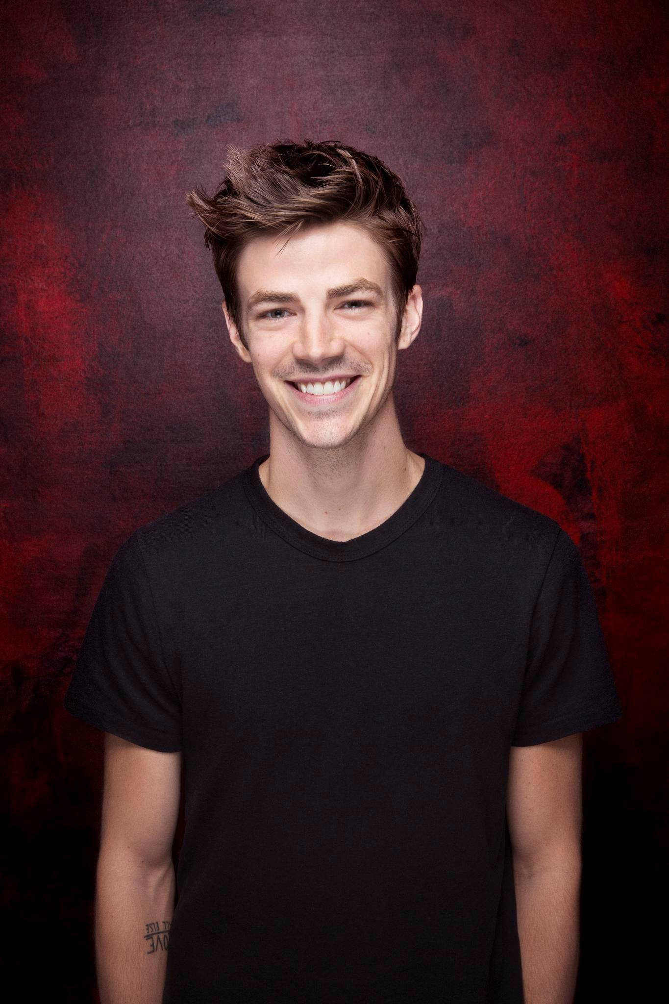 Grant Gustin, black tshirt, textured deep red studio backdrop, Full HD Phone Wallpaper