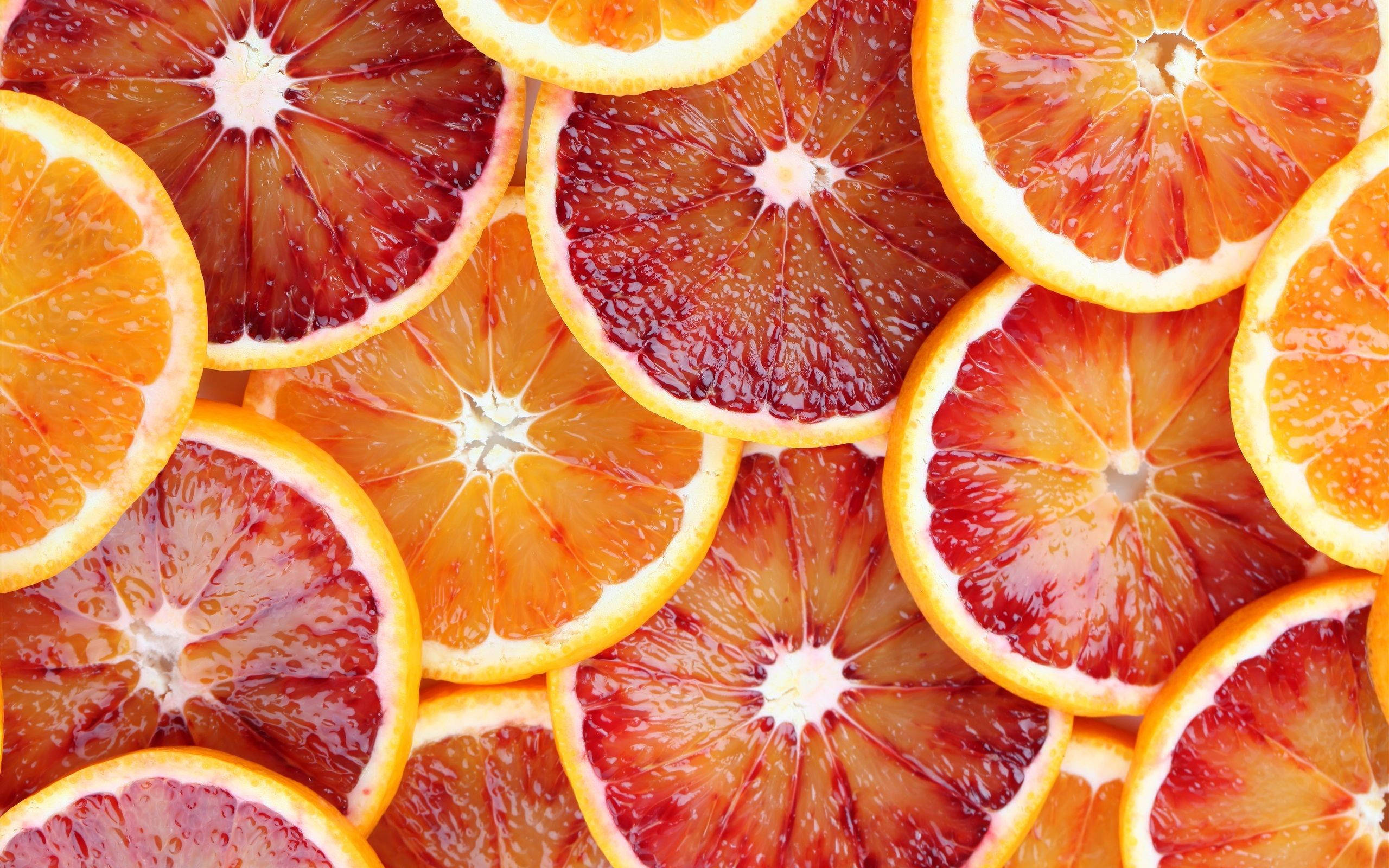 blood orange slices, deep red pulp, bright orange rinds, 2K Desktop Wallpaper