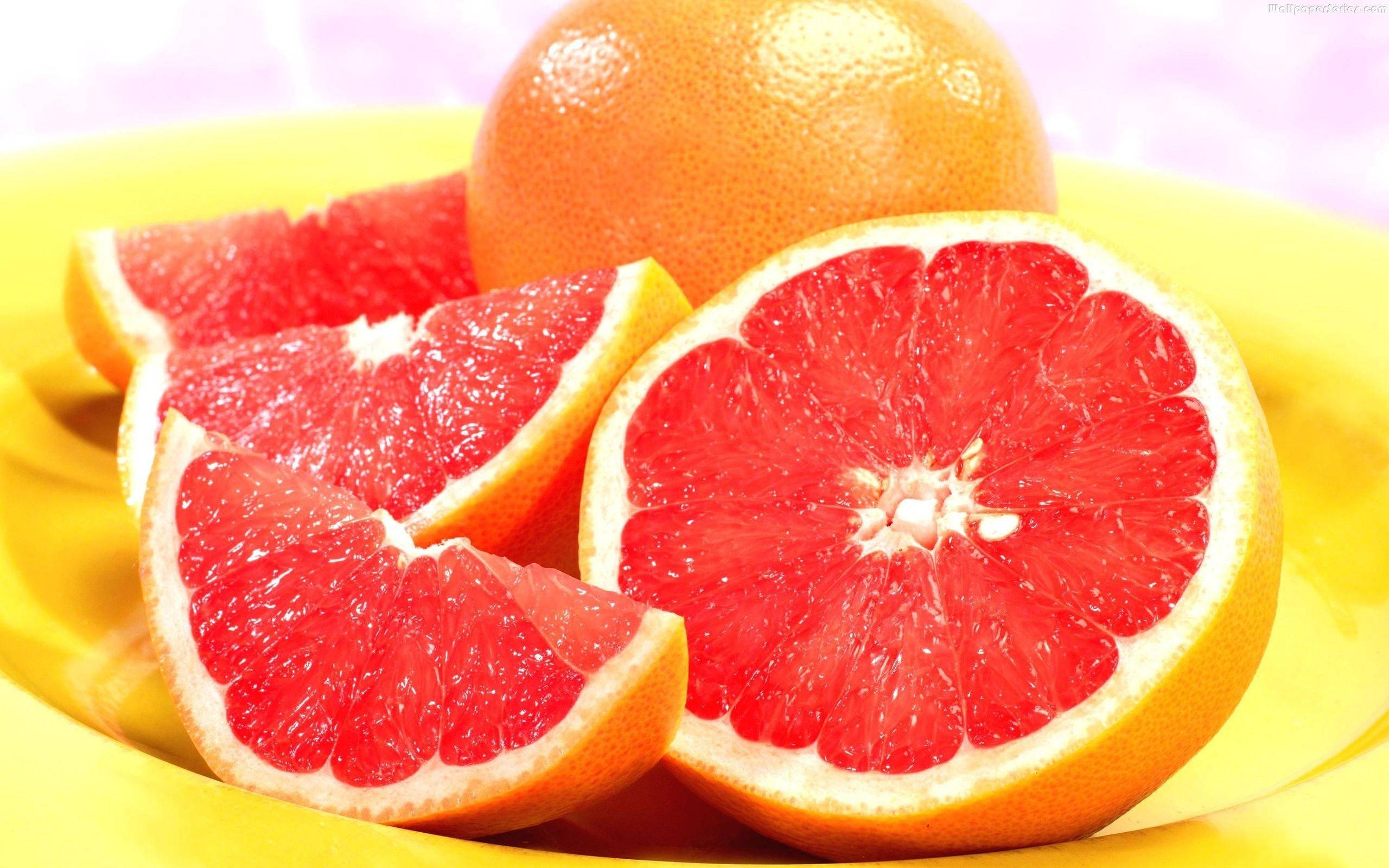 soft pink grapefruits, bright yellow plate, soft pink background, 2K Desktop Wallpaper