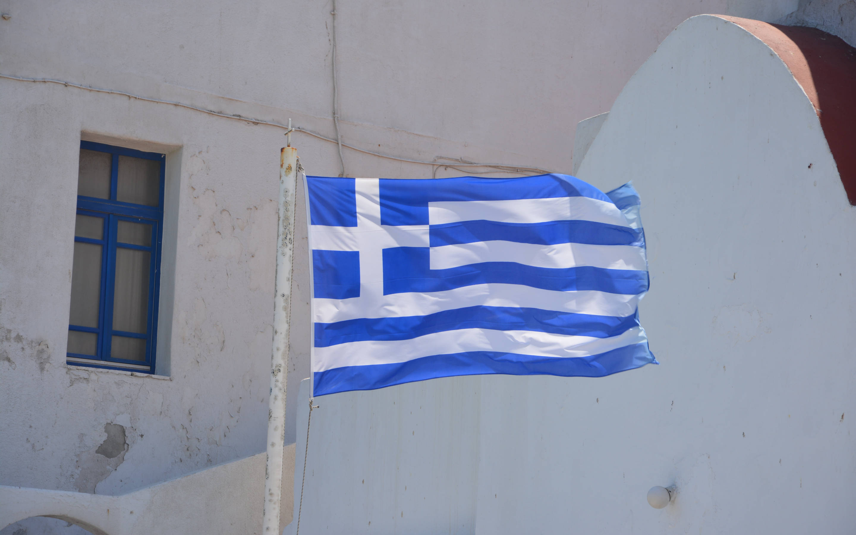 Greek flag, white-washed building, blue window, 2K Desktop Wallpaper