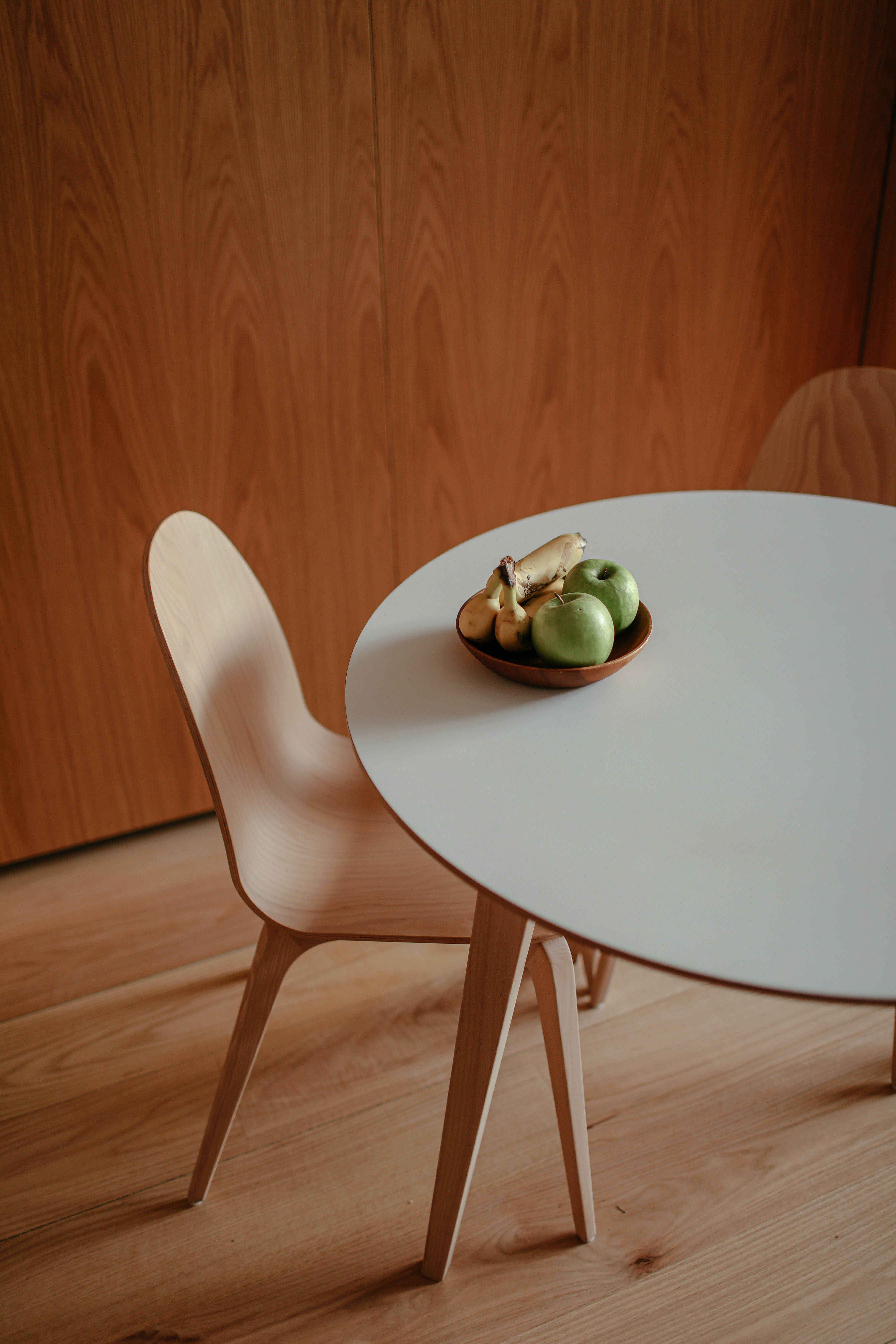 minimalist wooden table, bowl of green apples and bananas, matching chair, 5K Phone Wallpaper