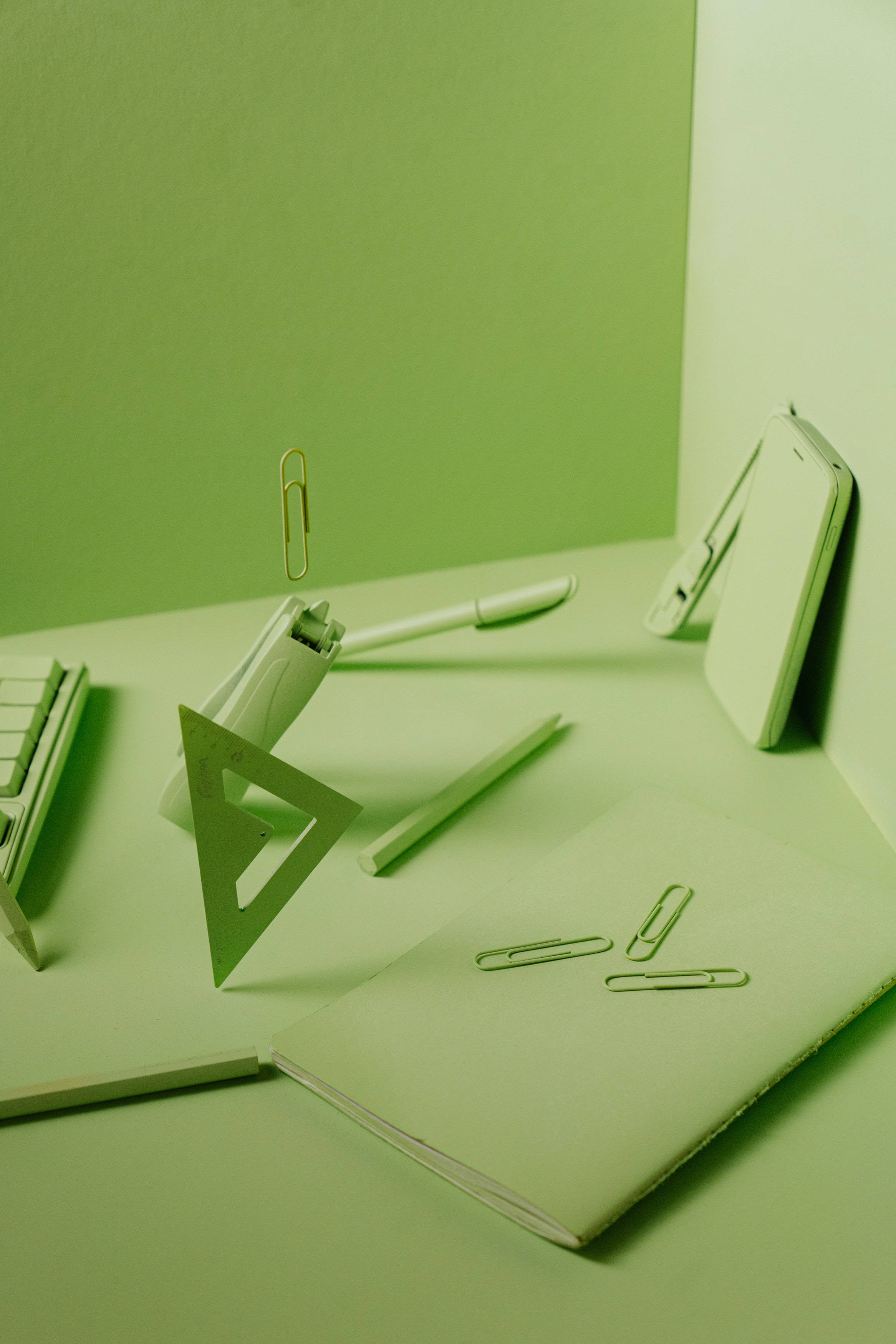 minimalist desk setup, stationery items, soft monochromatic green light, 2K Phone Wallpaper